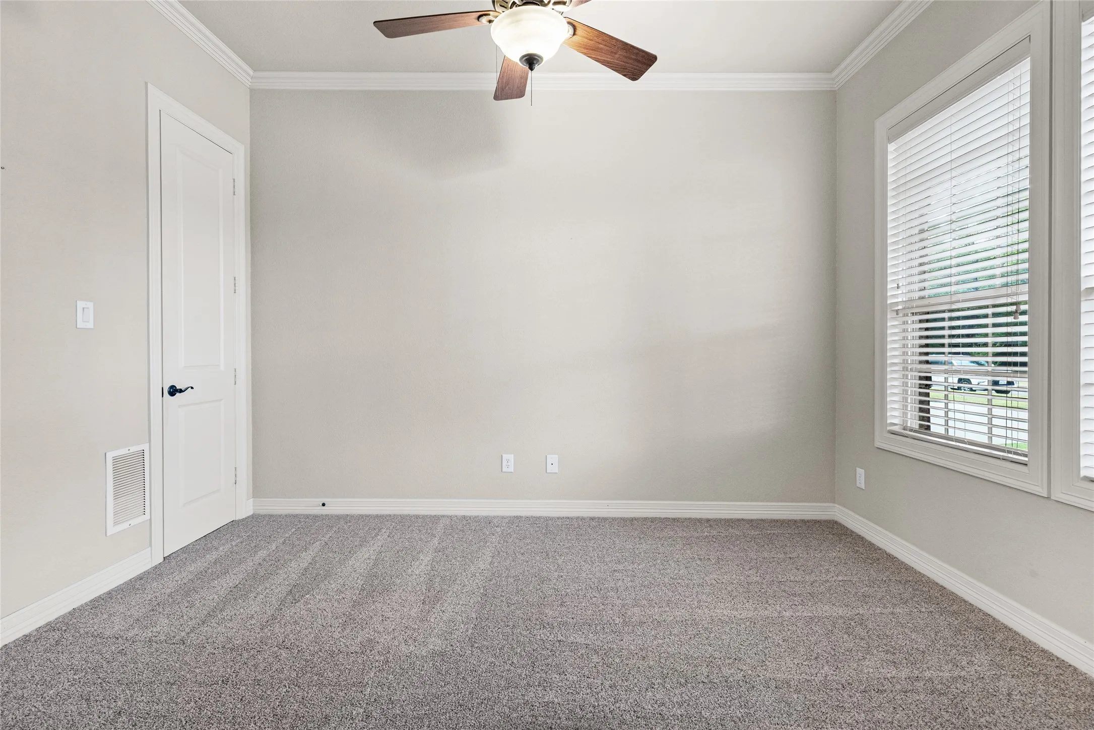 Neutral wall color, crown molding, ceiling fan, white trim, and gray carpet