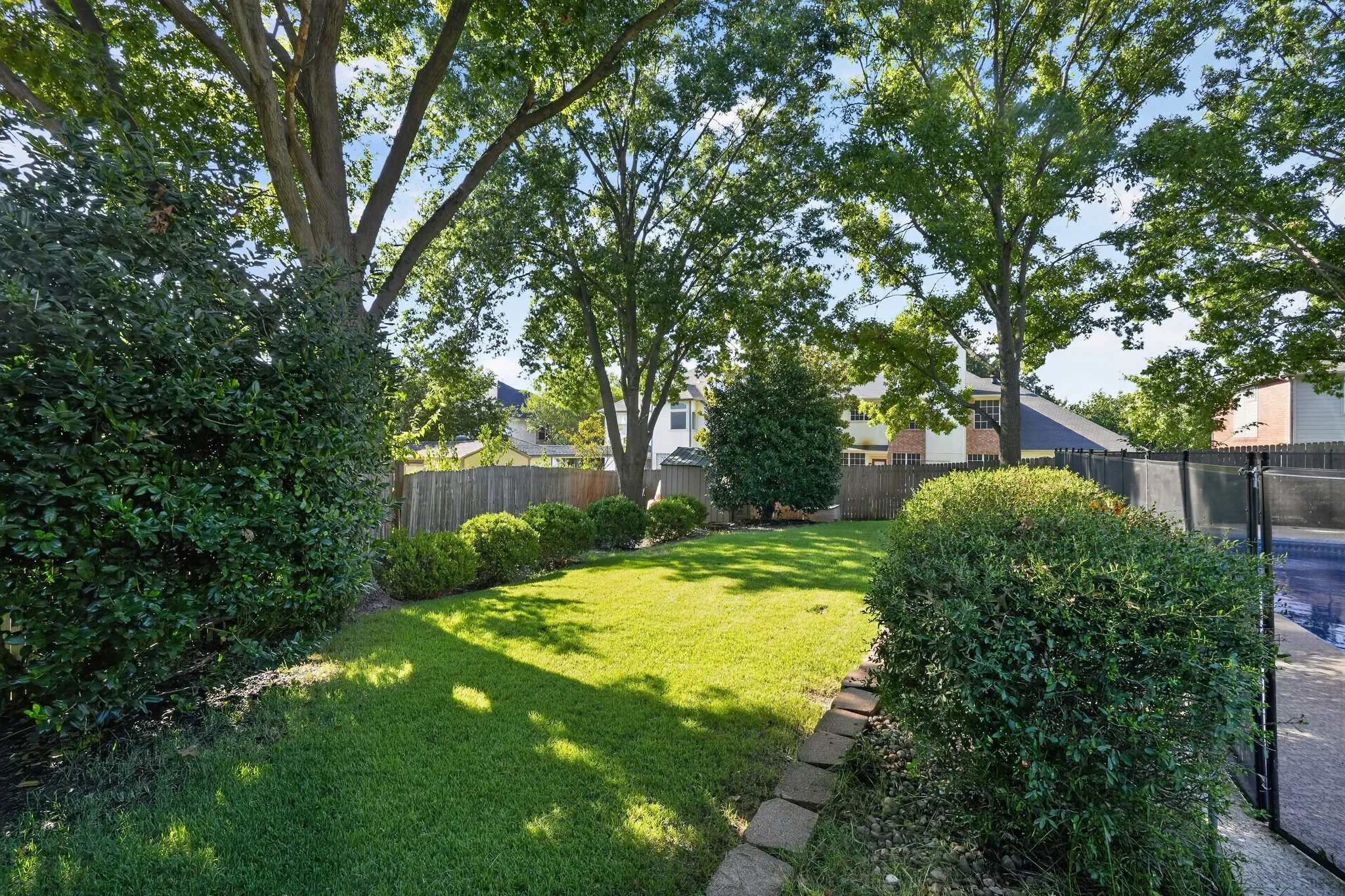 Backyard equipped with a shed, mature trees perfect for shade and running around