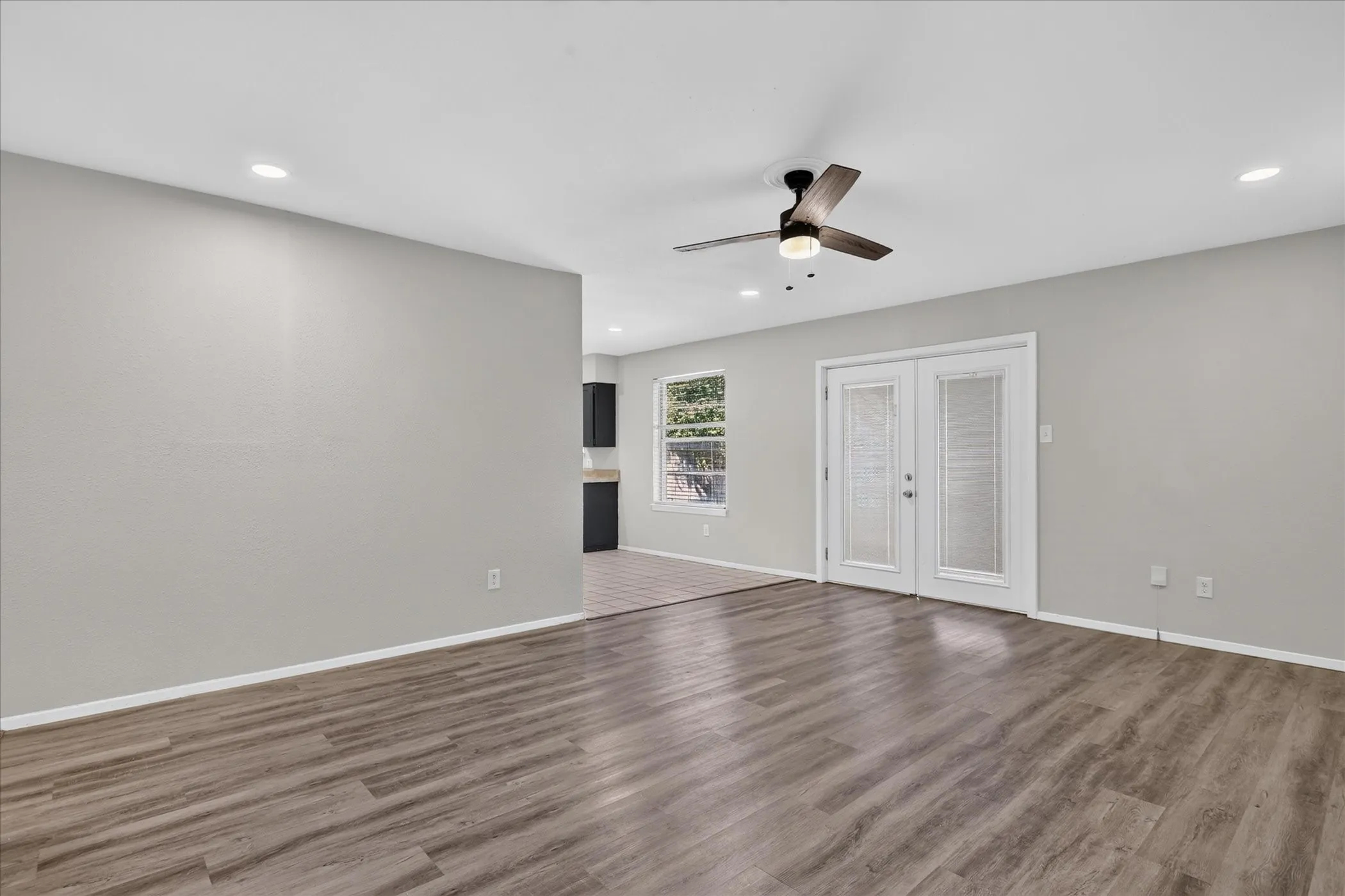 Kitchen featuring tile flooring, dark wood-finish cabinetry, a window with blinds, and recessed lighting