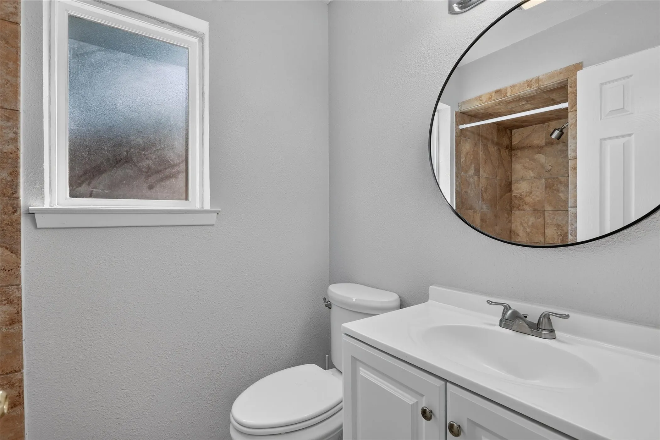 White vanity with integrated sink, dual-handle faucet, and white cabinetry