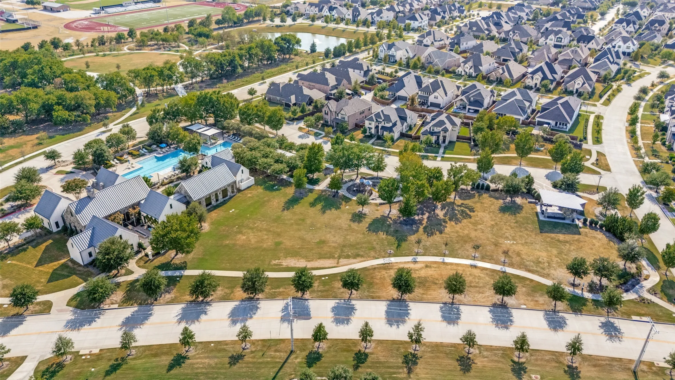 Community amenities featuring a swimming pool, clubhouse, open green spaces, and paved pathways