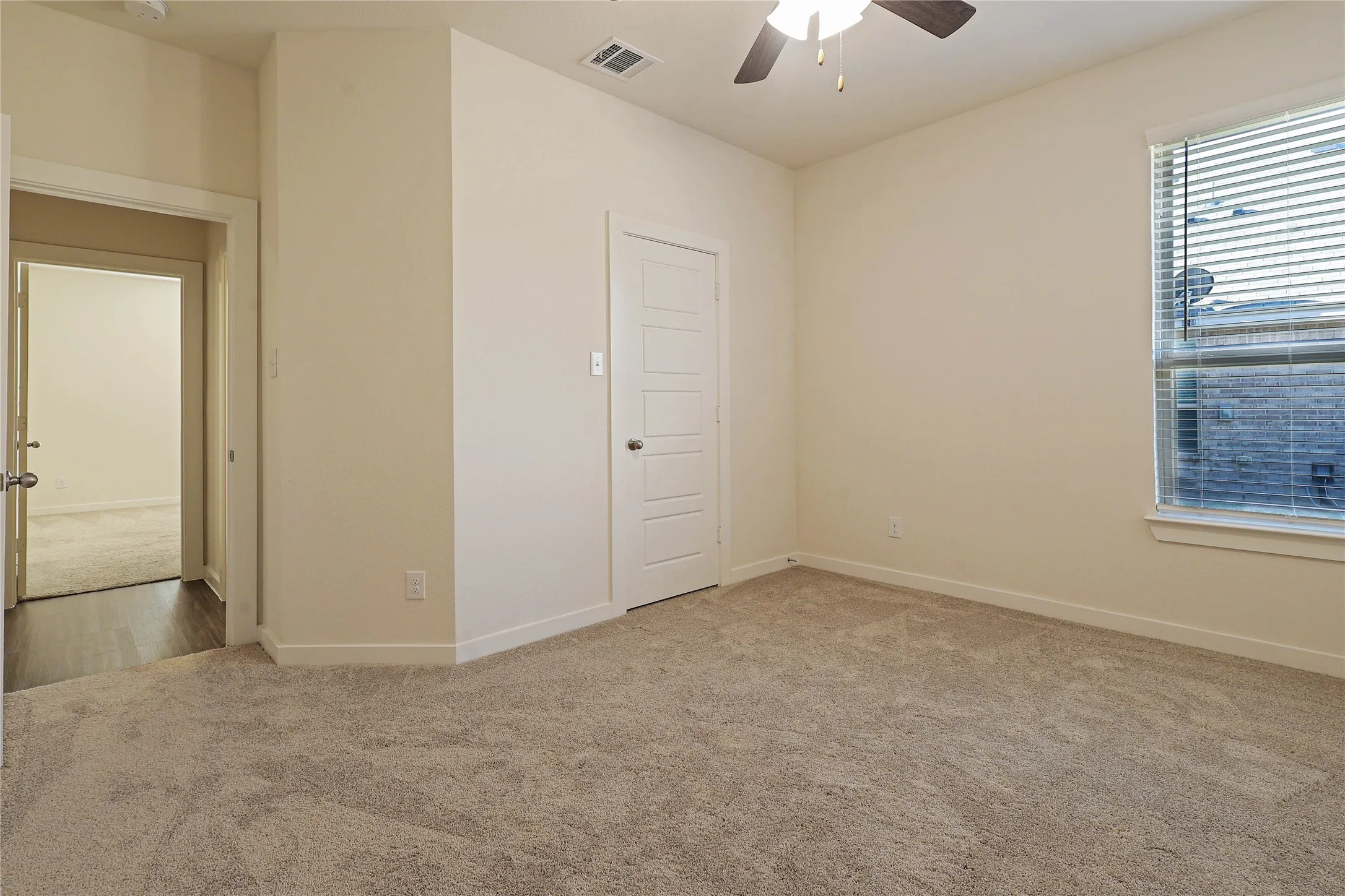 Neutral-toned walls complement the plush carpet flooring