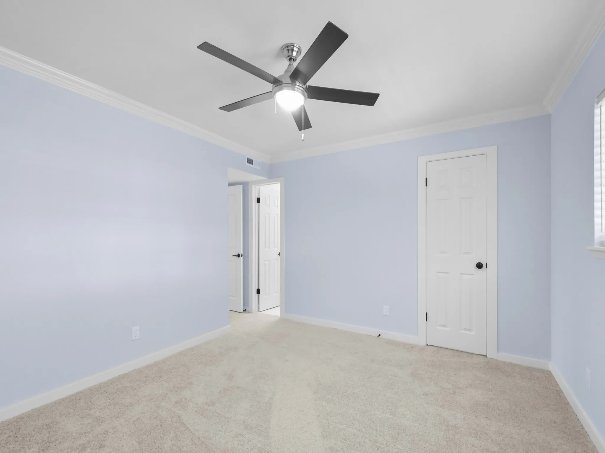 Plush carpet flooring, crown molding, and a ceiling fan with integrated lighting