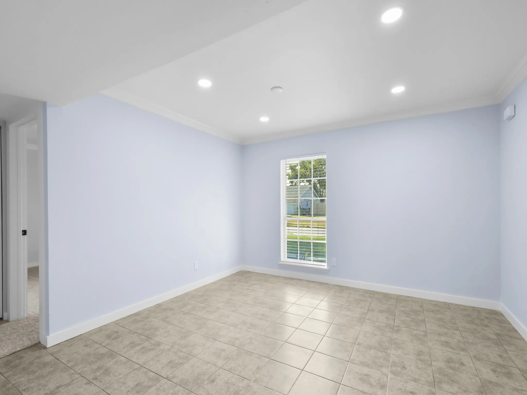 Recessed lighting, crown molding, rectangular window, tile flooring, and white trim