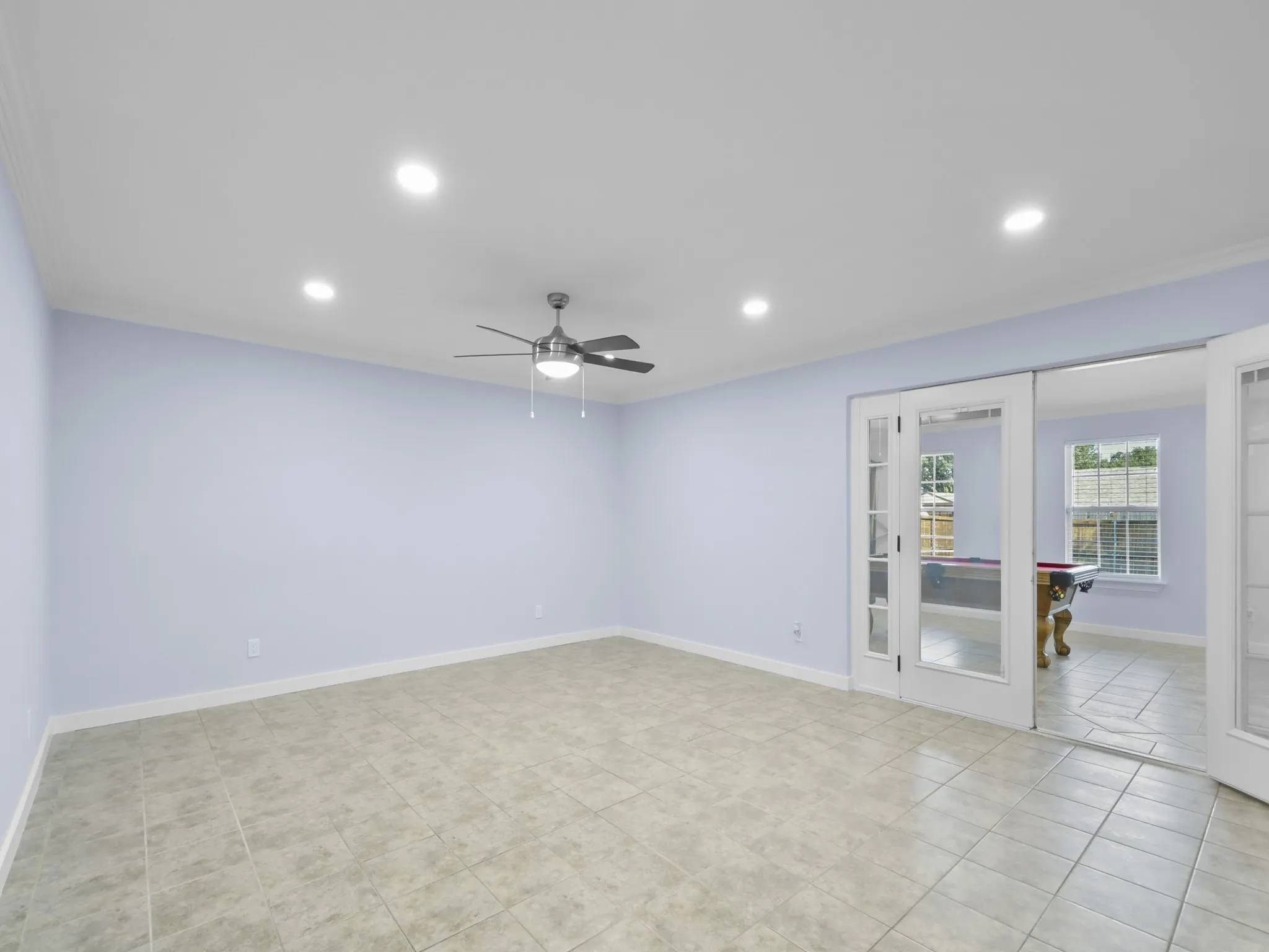 Recessed lighting, ceiling fan, tile flooring, crown molding, and French doors