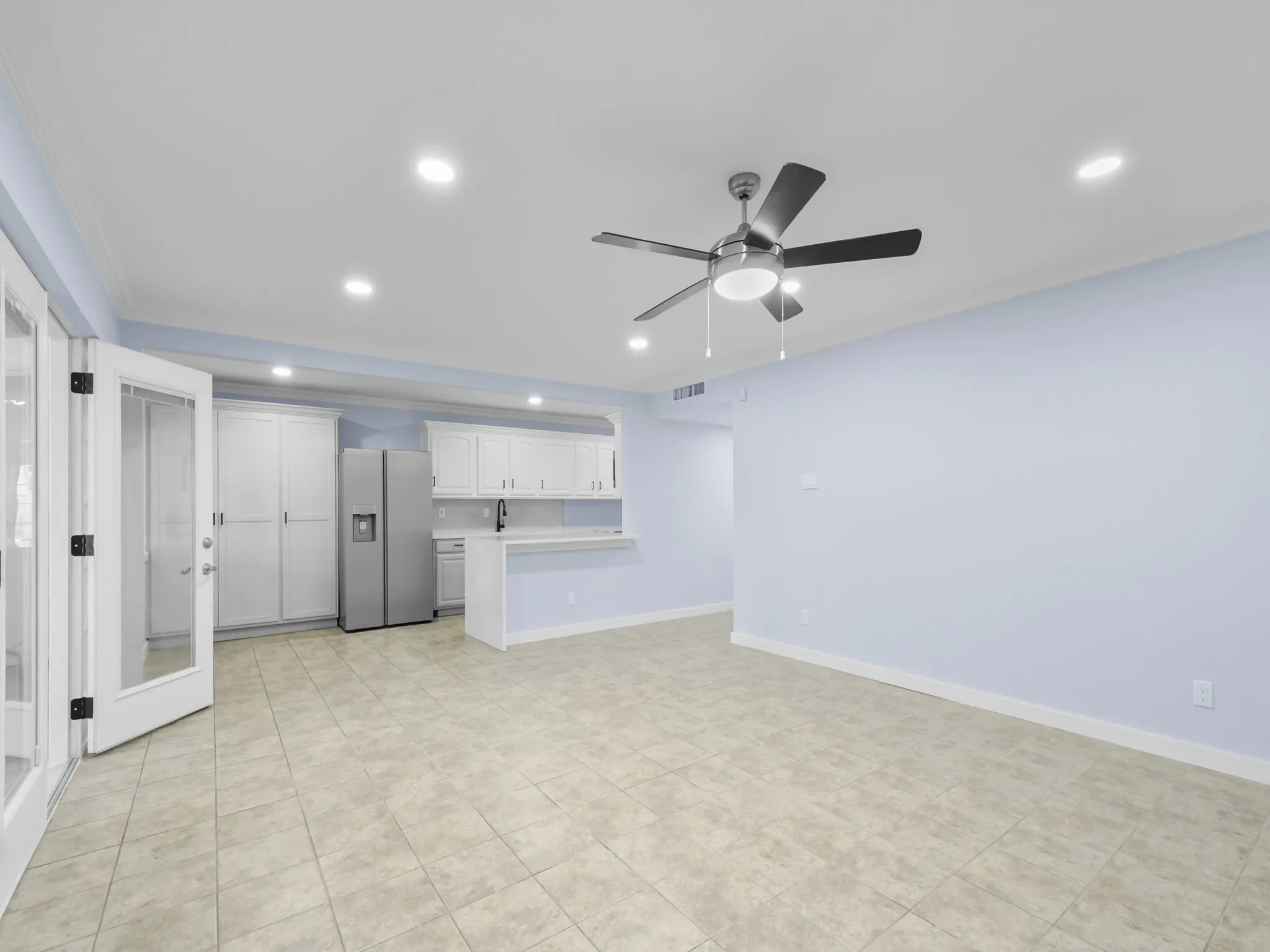 Open-concept living area with tile flooring, recessed lighting, and a ceiling fan