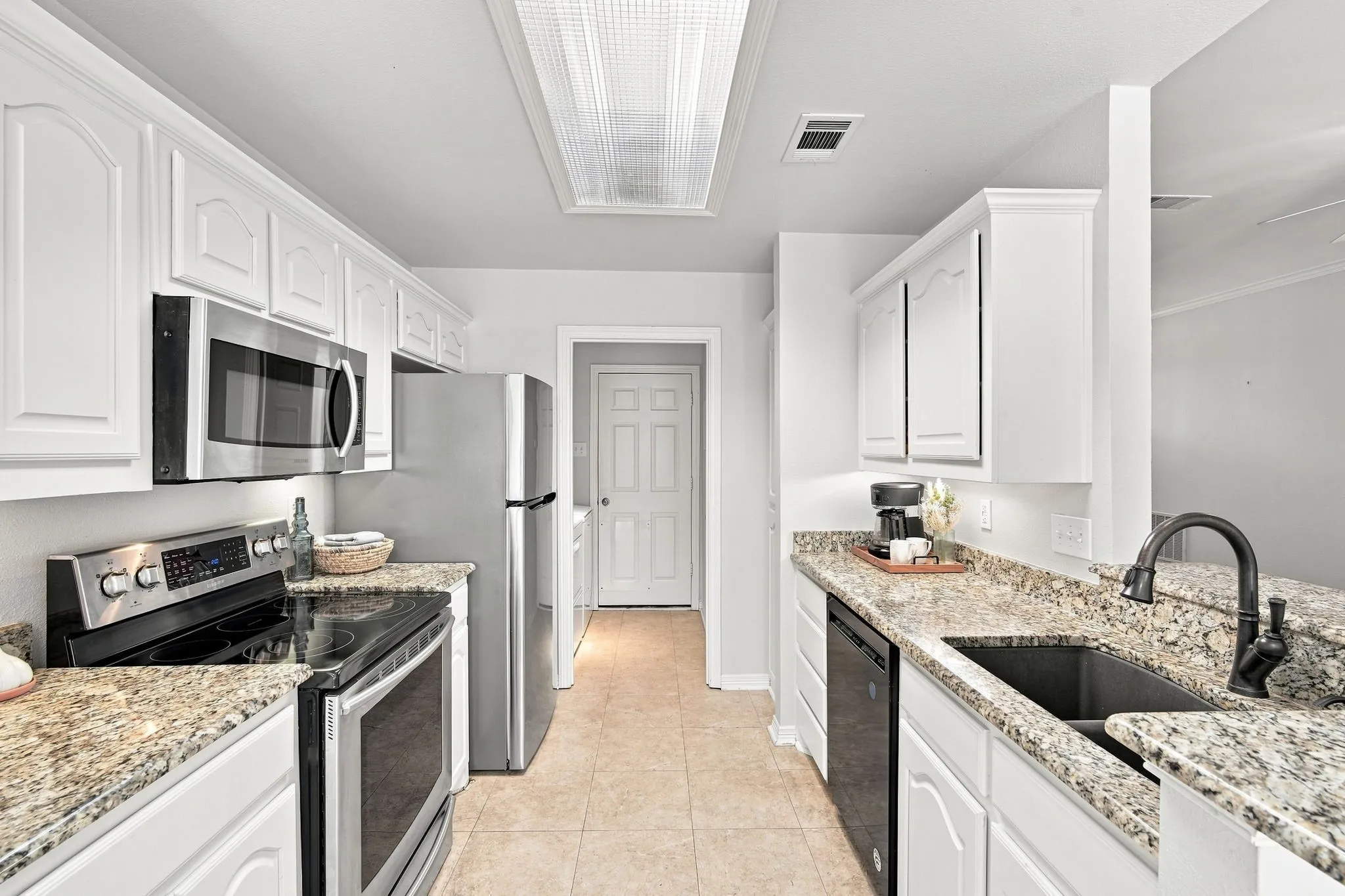 Your kitchen hosts a full SS appliance package, including refrigerator, alongside an abundance of granite countertops and built-in cabinets with a breakfast bar.