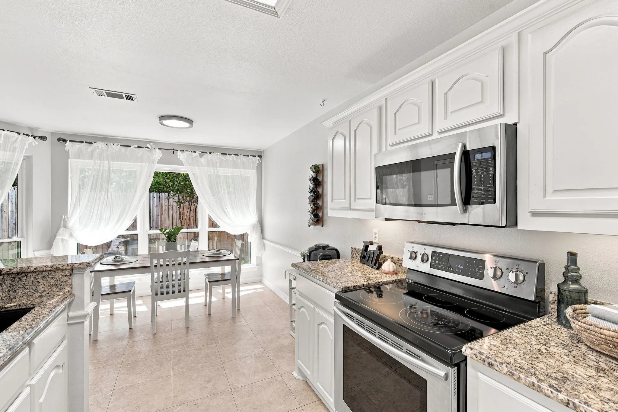 The fully-equipped kitchen transitions seamlessly into the breakfast room overlooking your backyard
