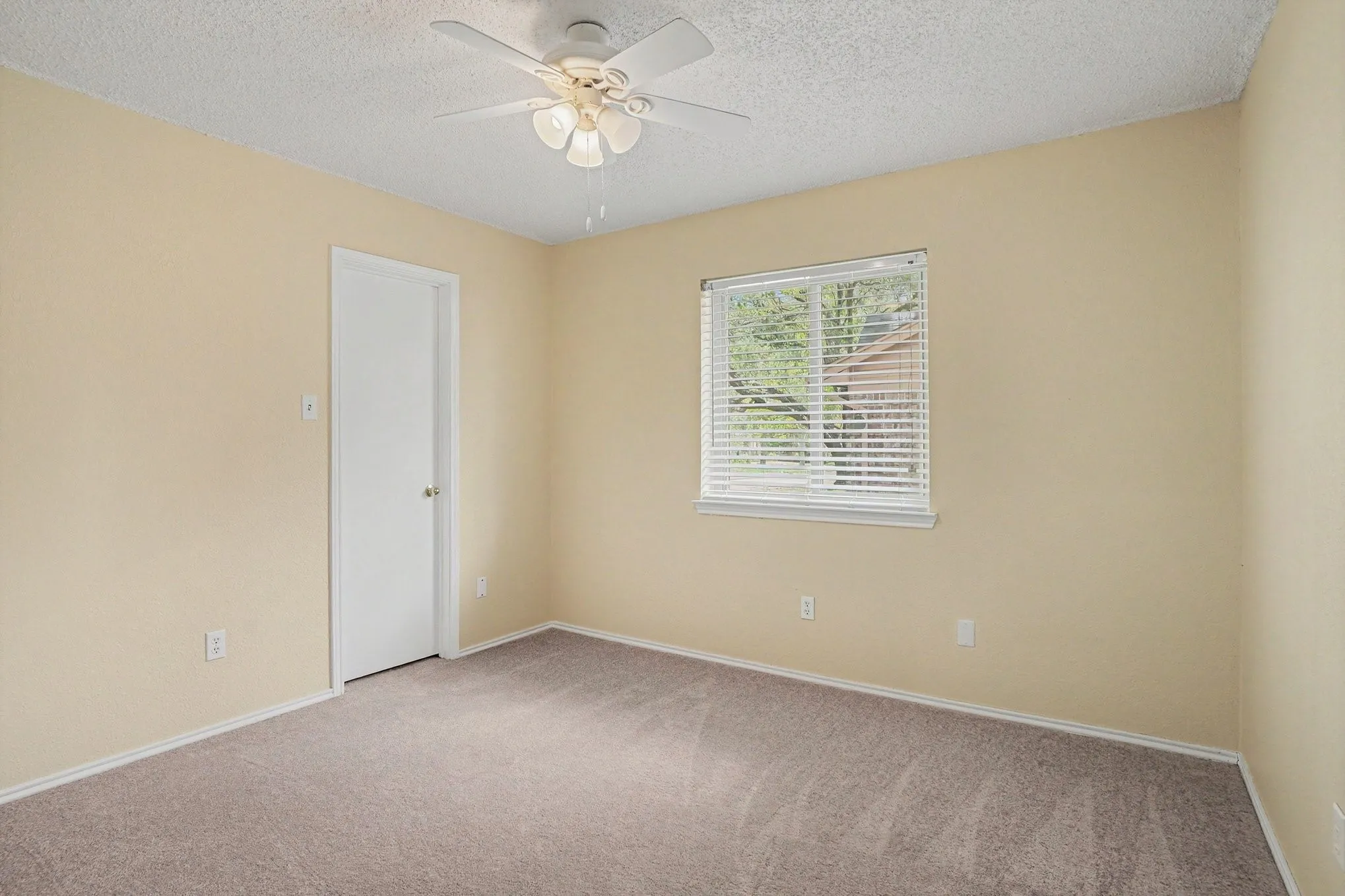 Carpeted interior with light-toned walls and a ceiling fan with integrated lighting