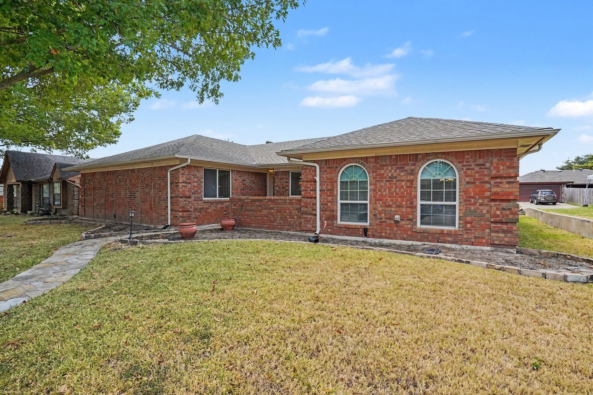Brick exterior featuring arched windows and a gabled roof