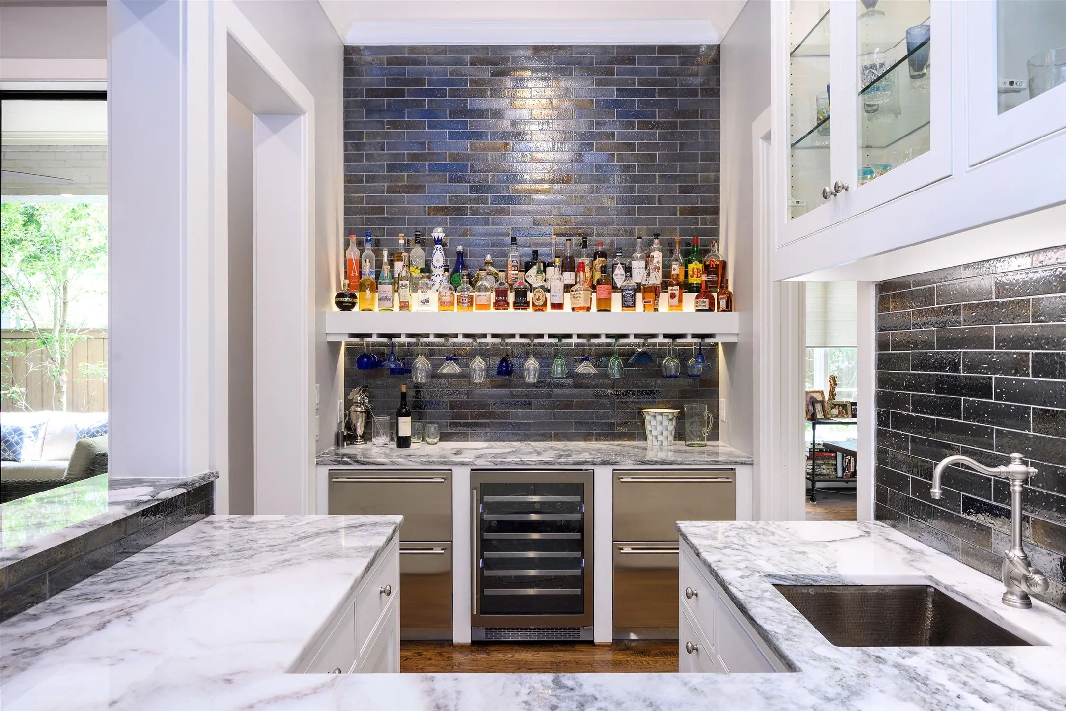 Wet bar with integrated wine refrigerator, under-cabinet lighting, glass-front cabinetry, and a subway tile backsplash