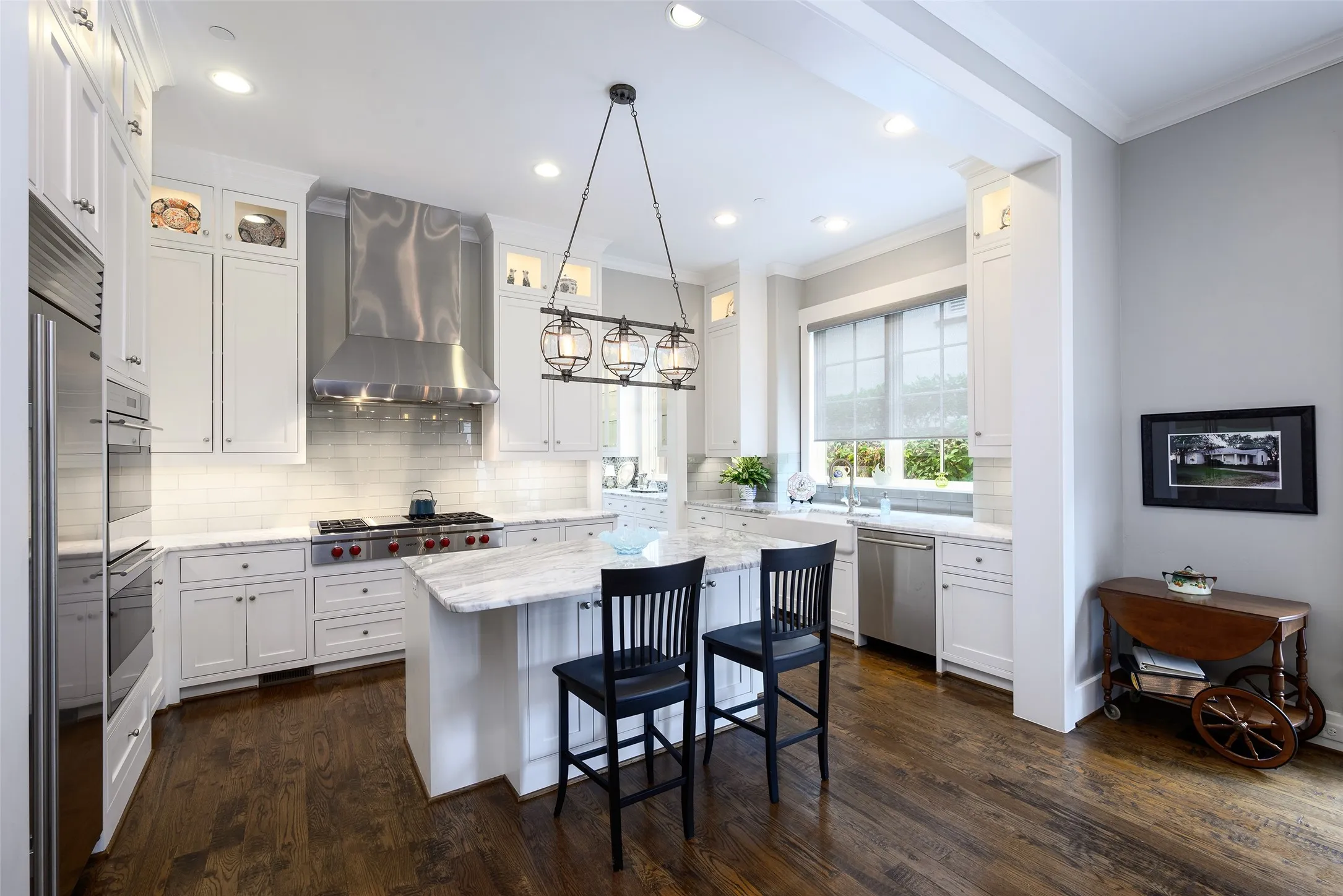 Kitchen featuring hardwood flooring, white cabinetry, granite countertops, a built-in range, and a stainless steel range hood