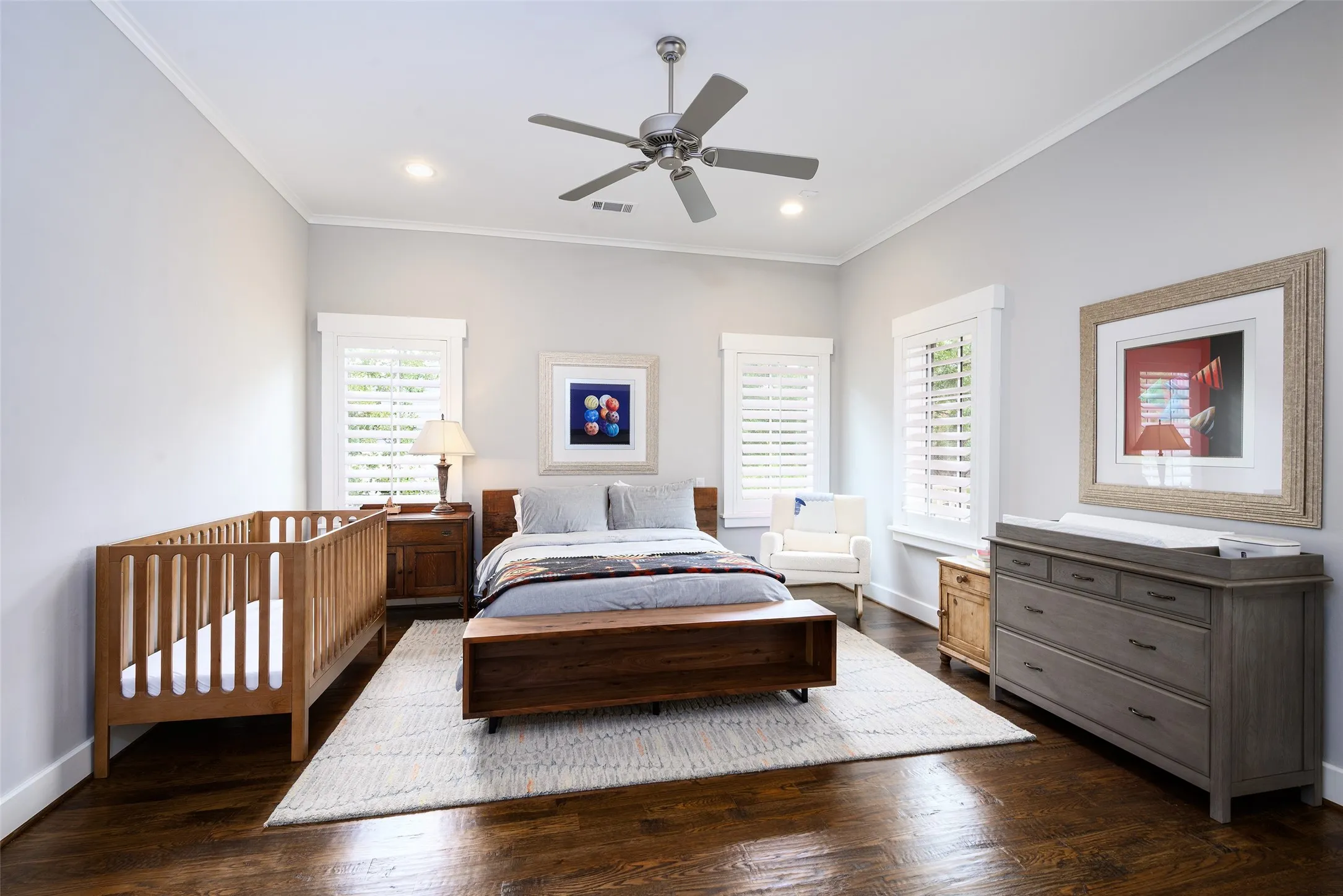 Recessed lighting and ceiling fan complement the bright interior with rich, dark wood flooring