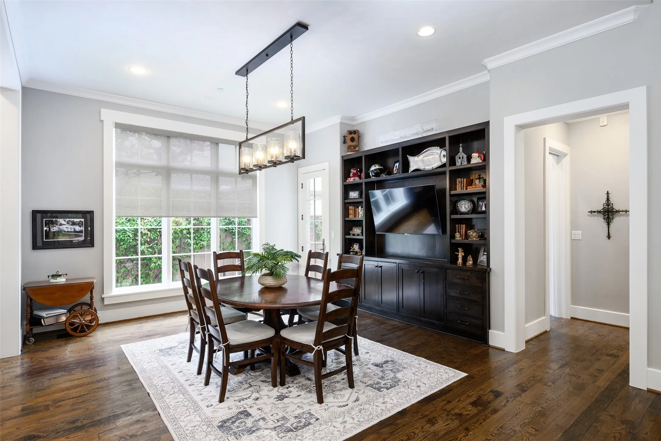 Hardwood flooring, recessed lighting, built-in shelving, crown molding, and a rectangular multi-light chandelier