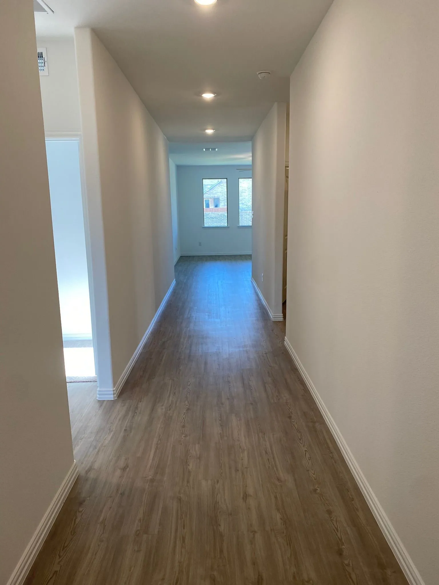 Recessed lighting illuminating wood-finish flooring