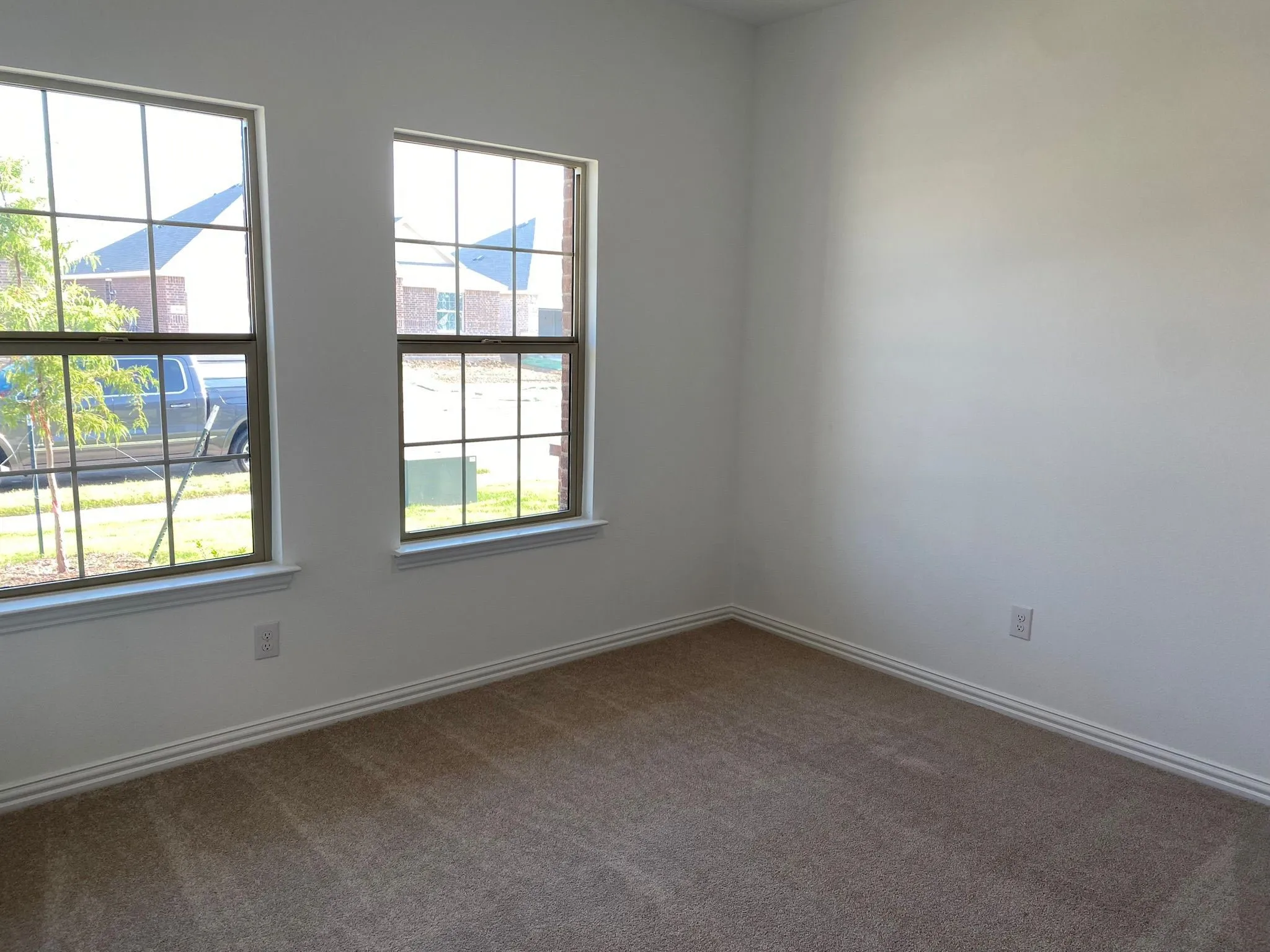 Neutral wall paint, dual windows, window sills, and carpet flooring