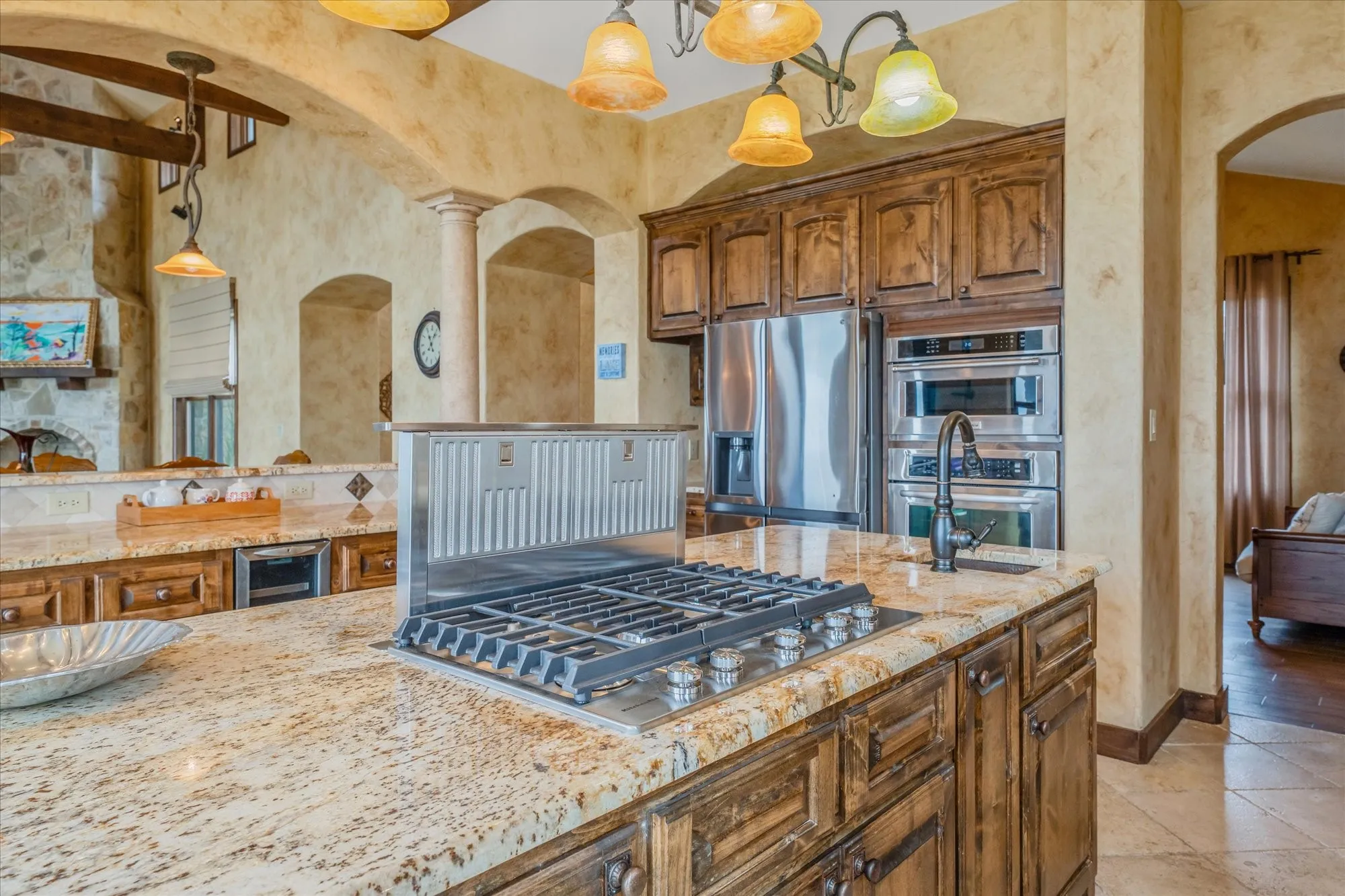 Gourmet kitchen with granite countertops, wood cabinetry, stainless steel appliances, a gas cooktop, and a built-in oven