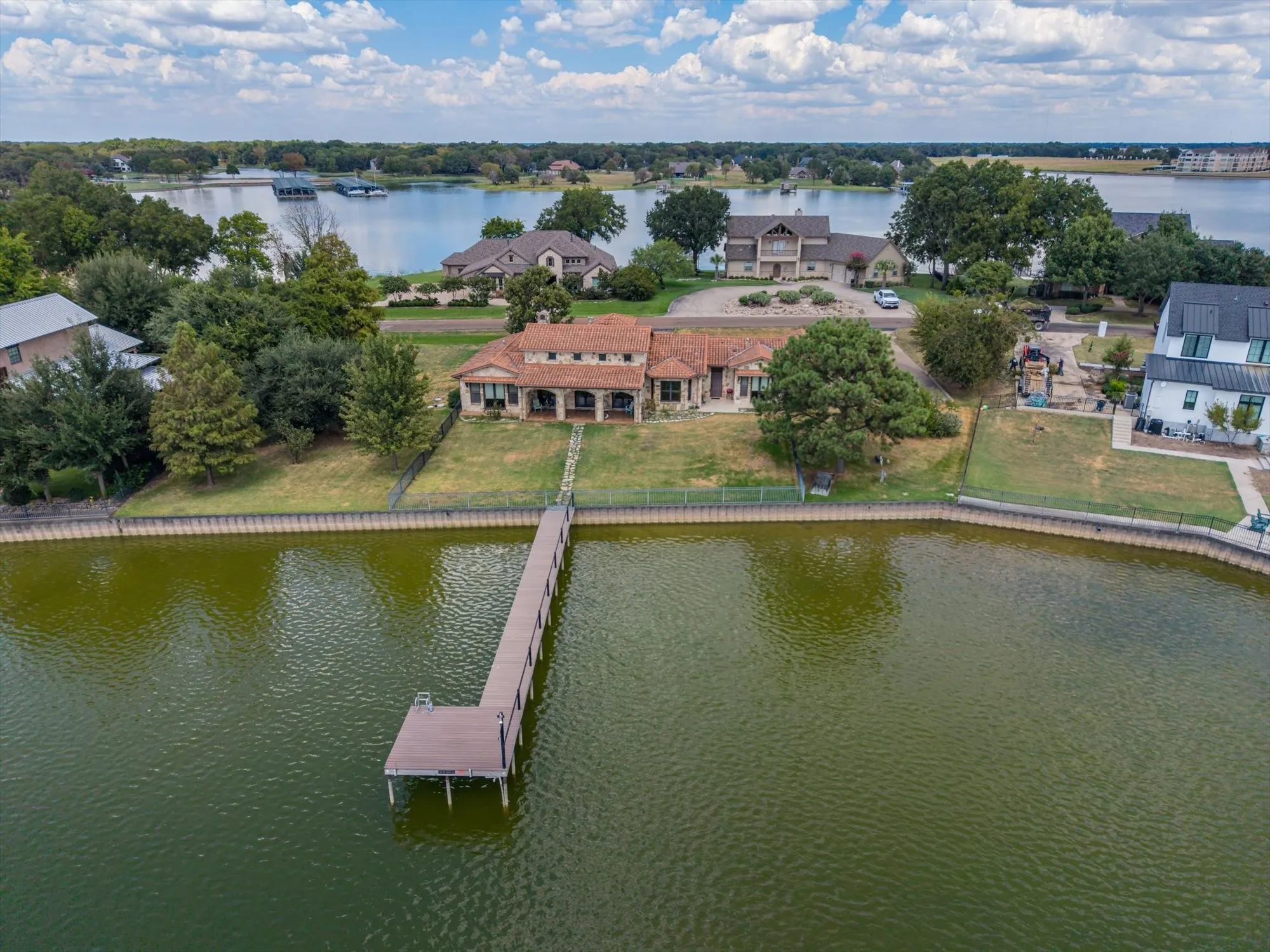 Waterfront property featuring a private dock, expansive lake frontage, and a Mediterranean-style residence