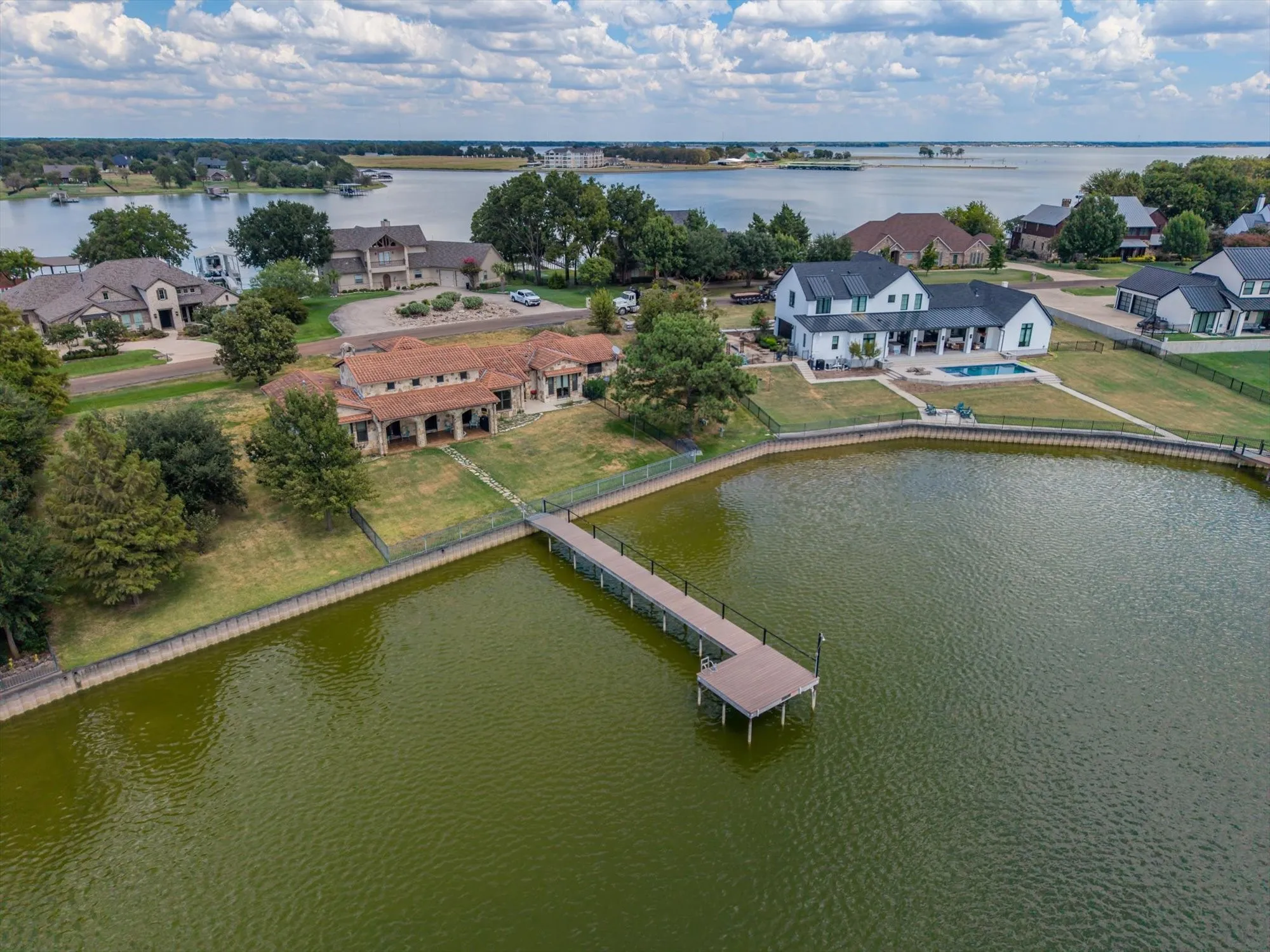 Lakefront property featuring a private dock, expansive lawn, and direct water access