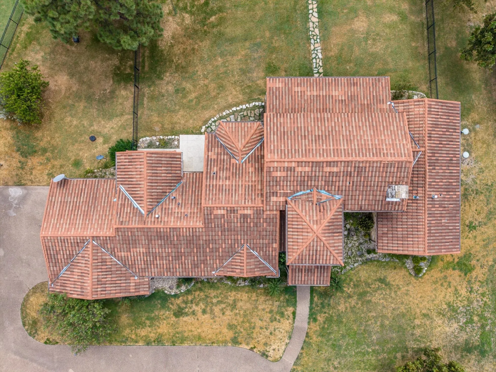 Red clay tile roofing with multiple gables and a central turret structure