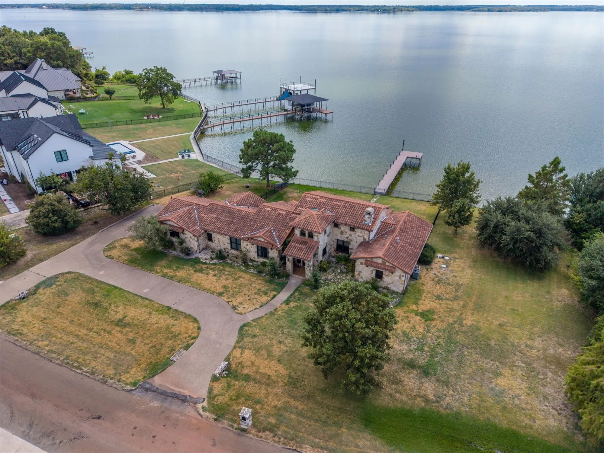Stone exterior residence with a tile roof, featuring a private dock and direct water access