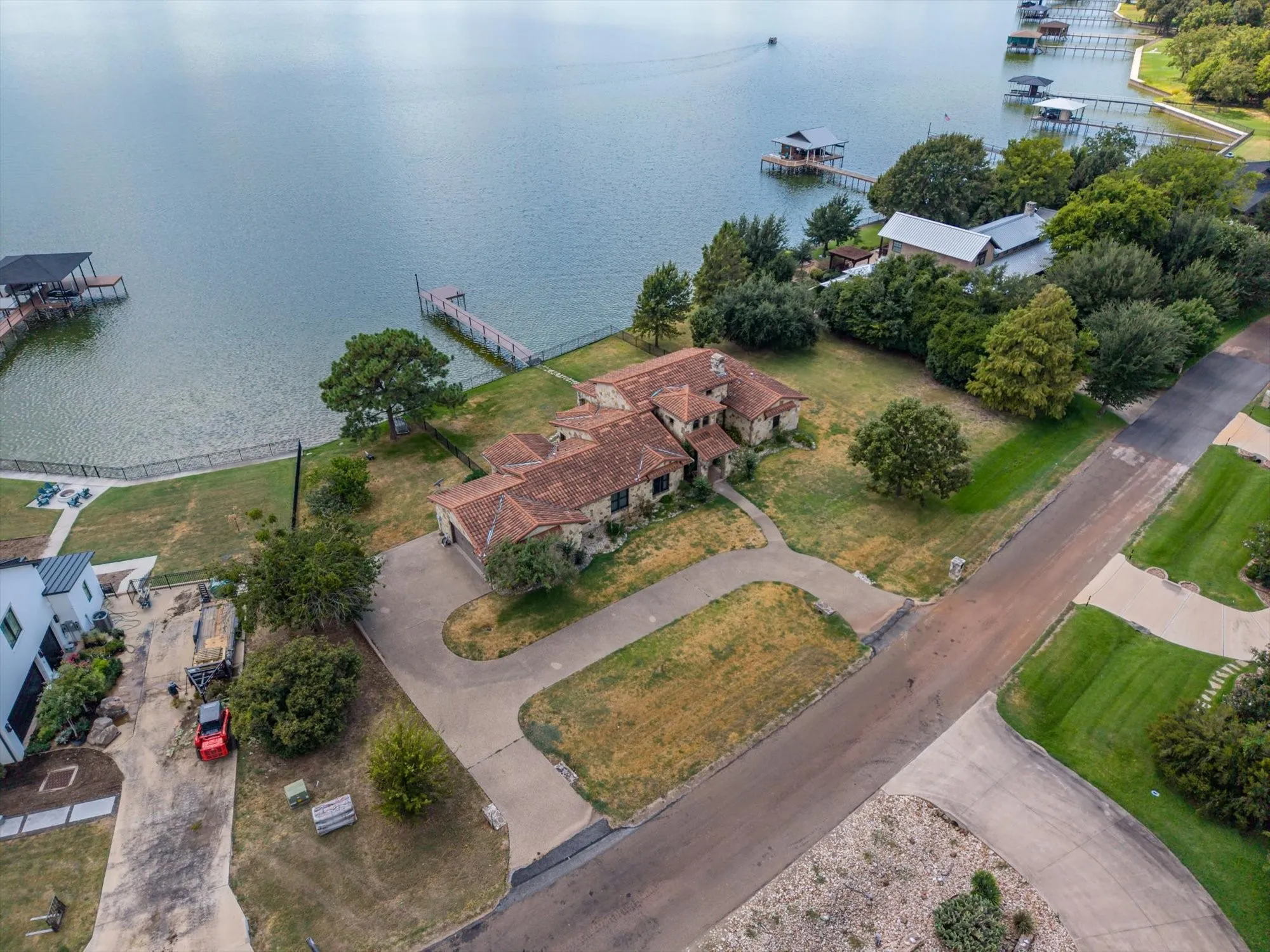 Waterfront property featuring a private boat dock, stone exterior, and a tiled roof