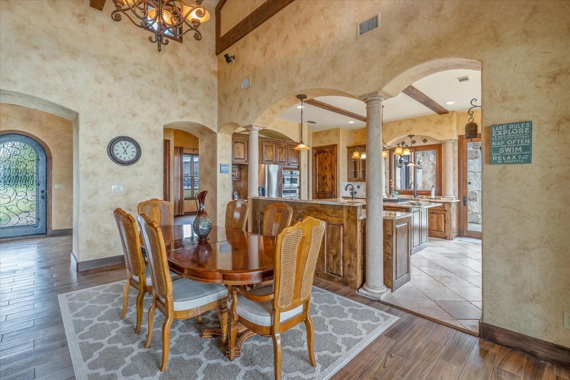 High ceilings with exposed wood beams, arched doorways, and columns