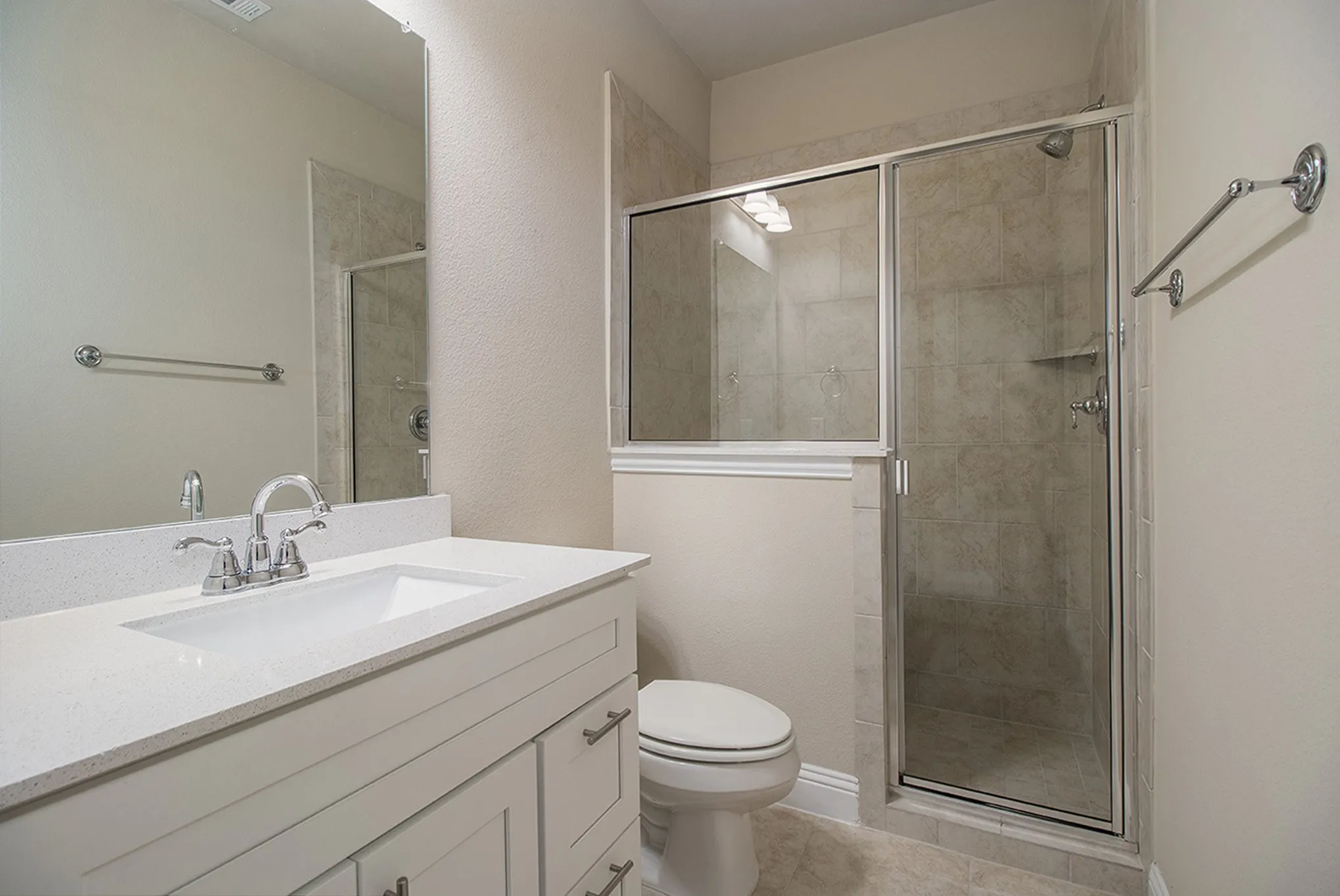 Bathroom with a vanity featuring a white countertop and an integrated sink, chrome faucet, and a mirror
