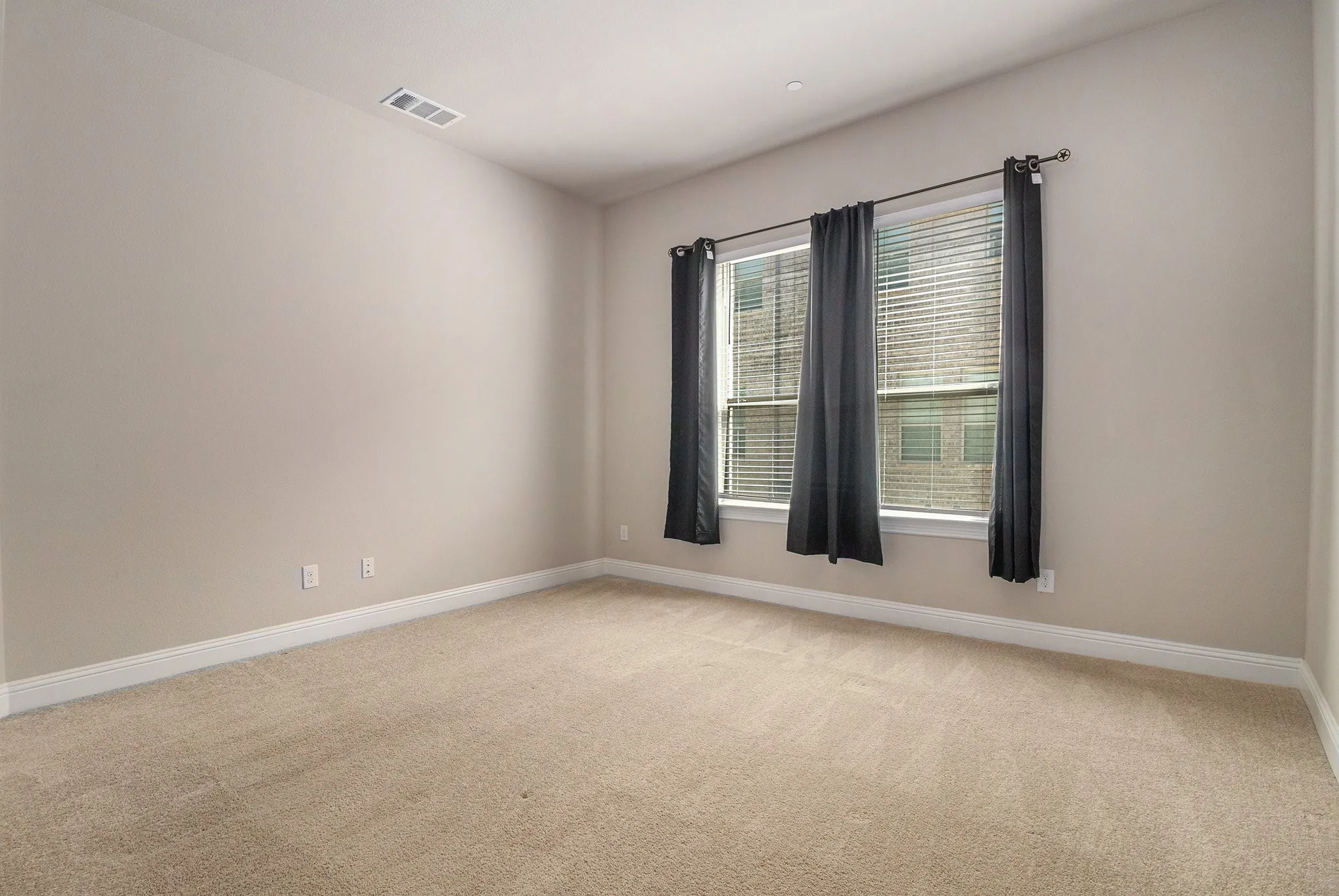 Neutral tone wall paint, carpeted flooring, multiple windows, window blinds, and white trim
