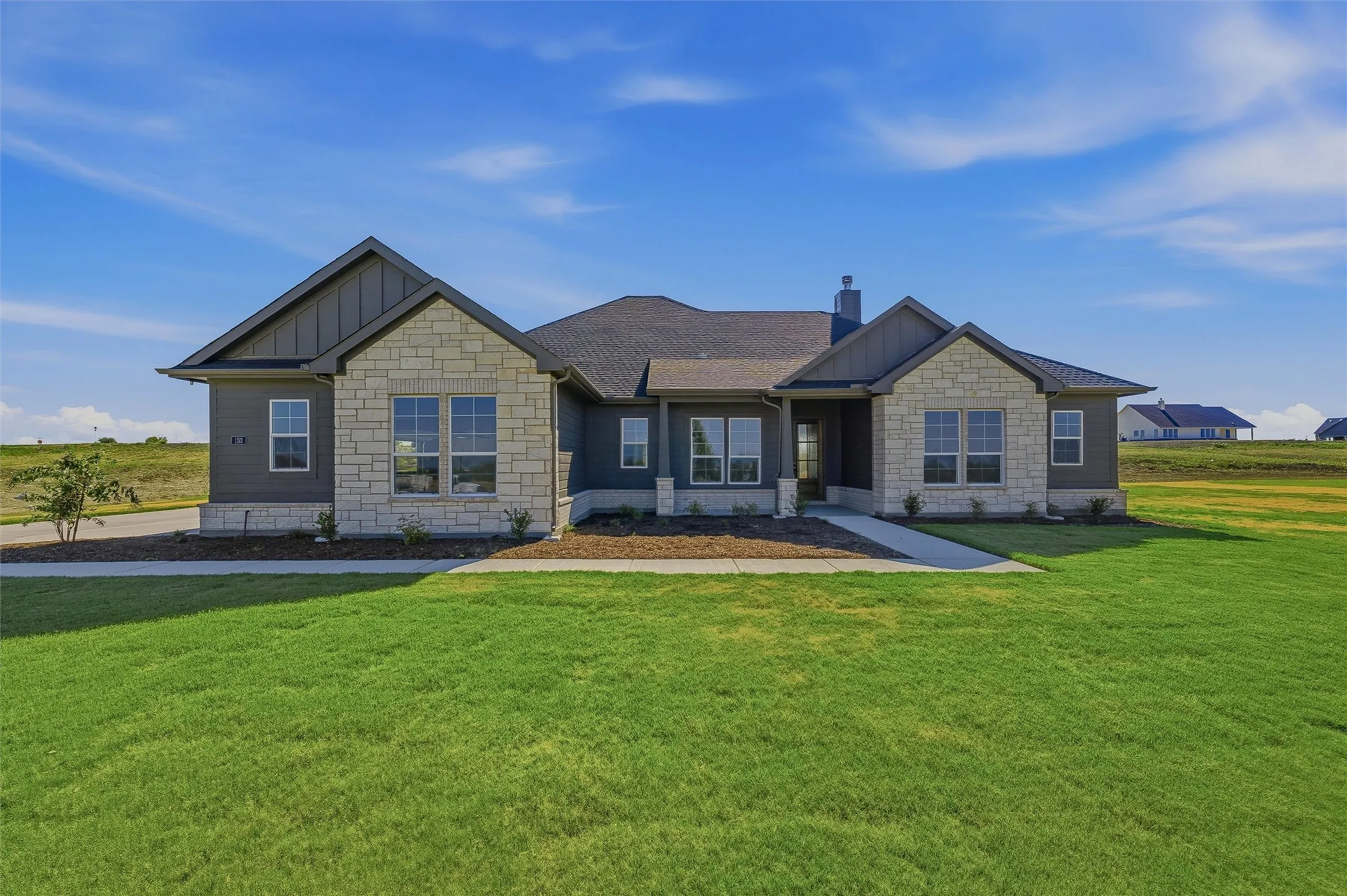 Stone and siding exterior with dark trim accents