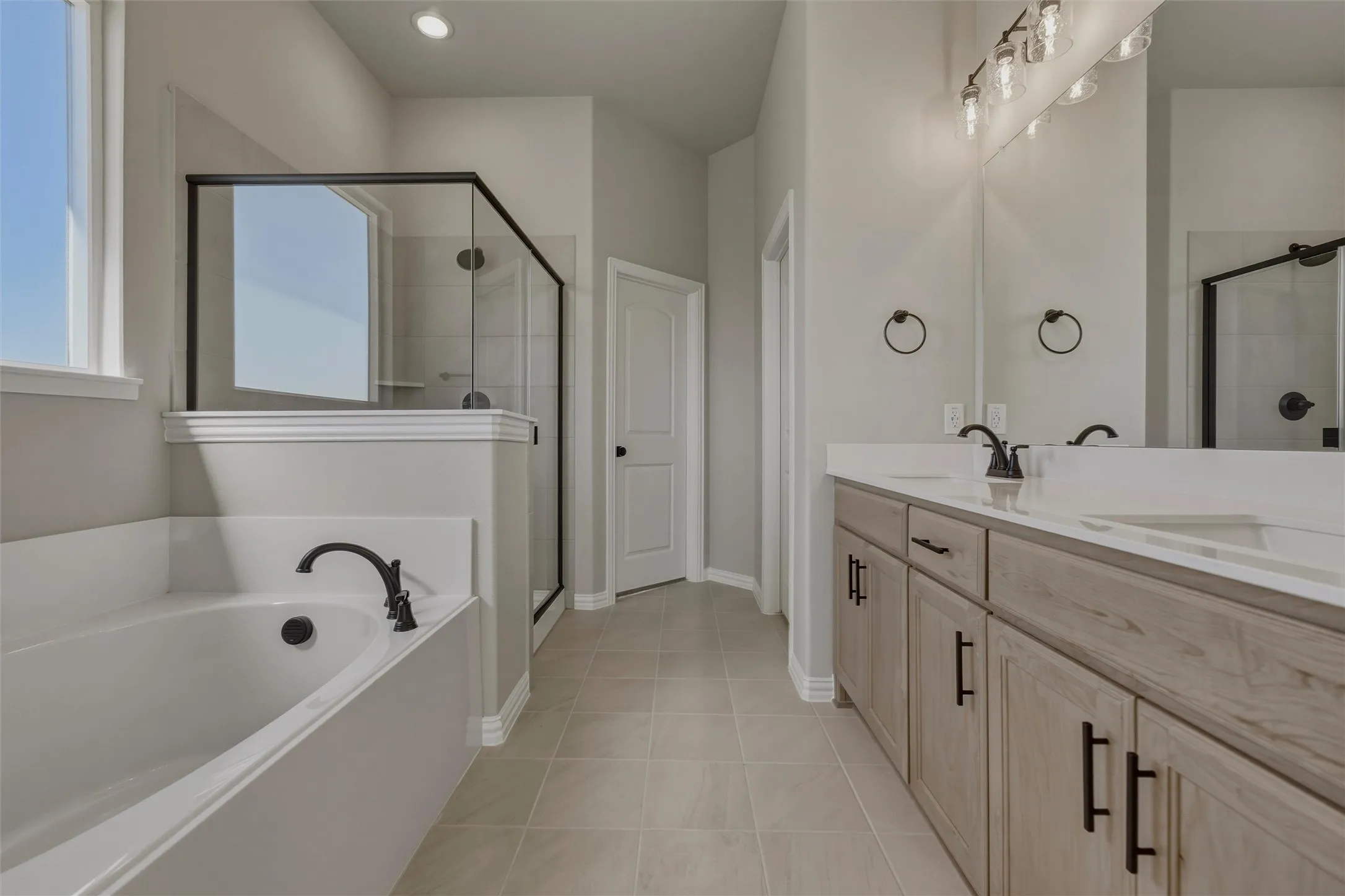 Dual vanity with light wood-finish cabinetry and white countertops