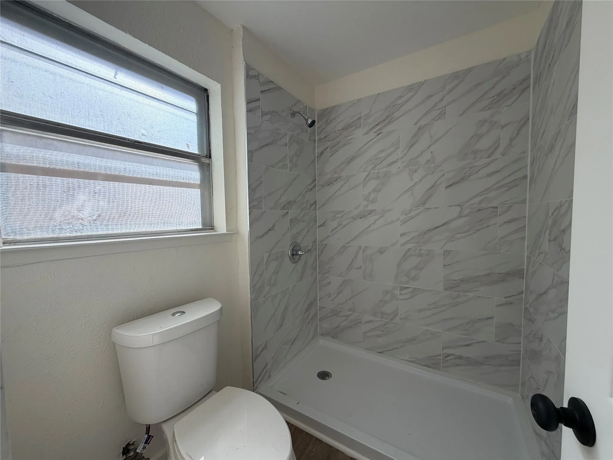 Walk-in shower with tiled surround and chrome fixtures