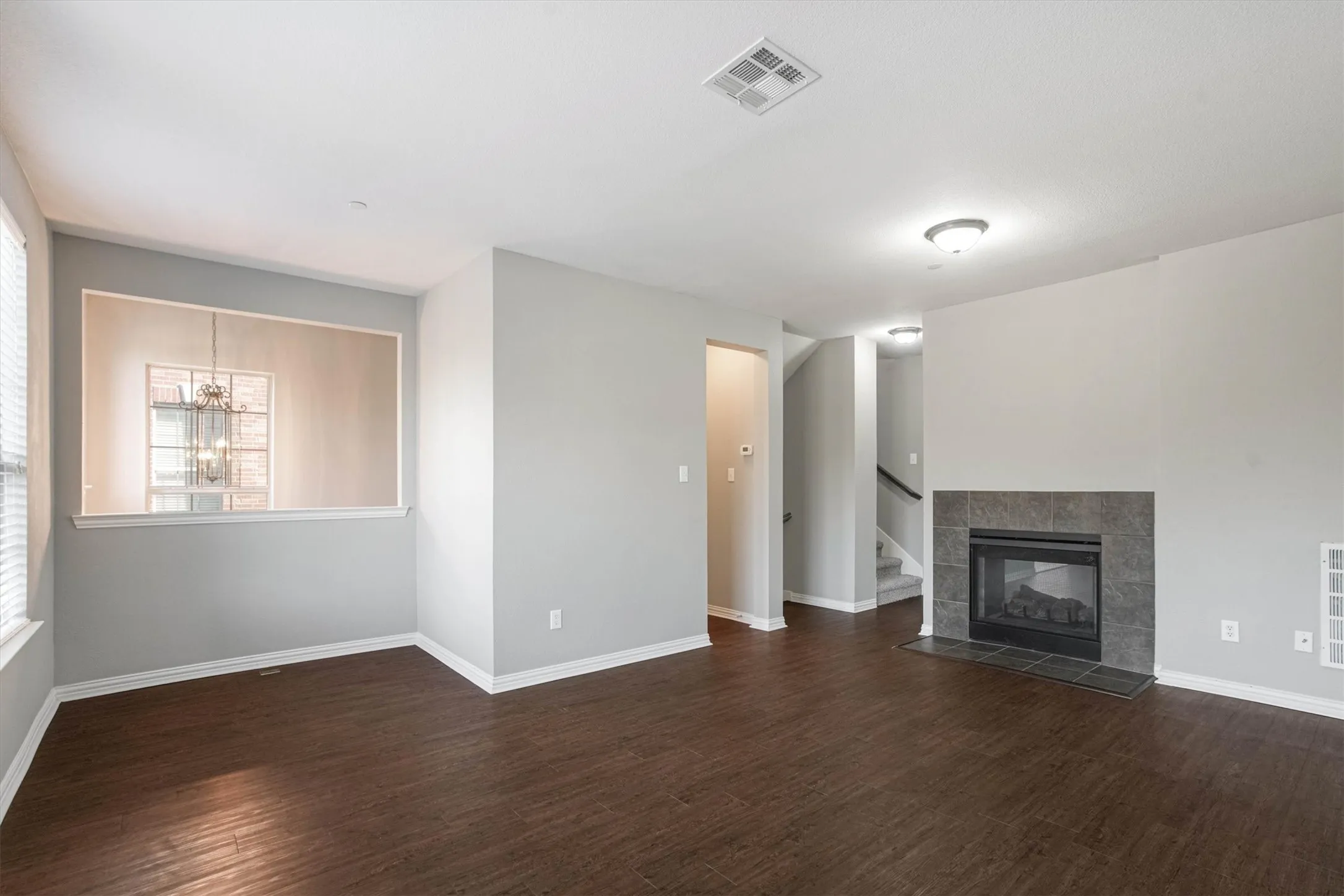 Spacious living room on the main floor with a double-sided fireplace. Light and bright with lots of space.