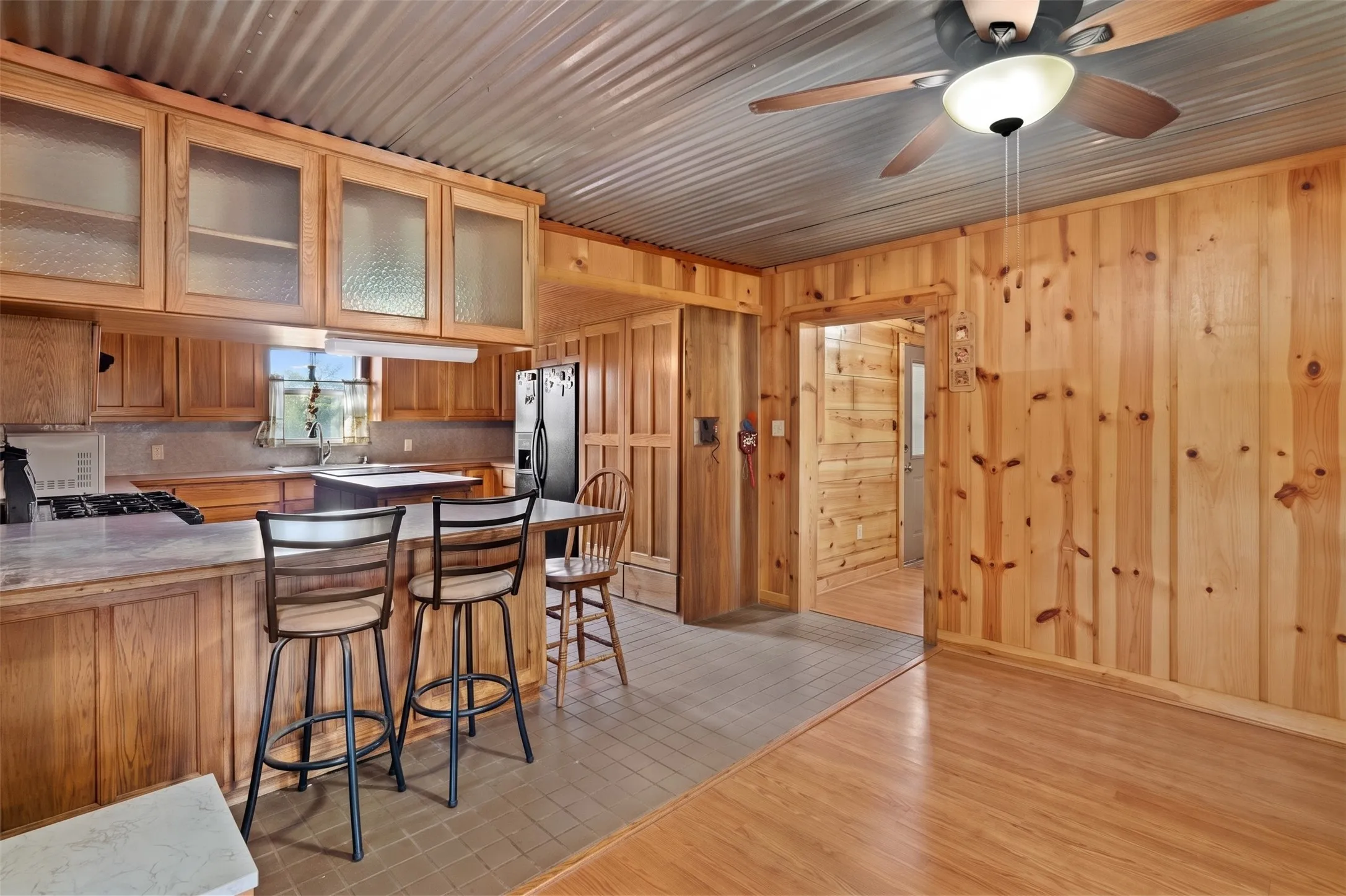 Kitchen featuring wood cabinetry with frosted glass uppers and a built-in range