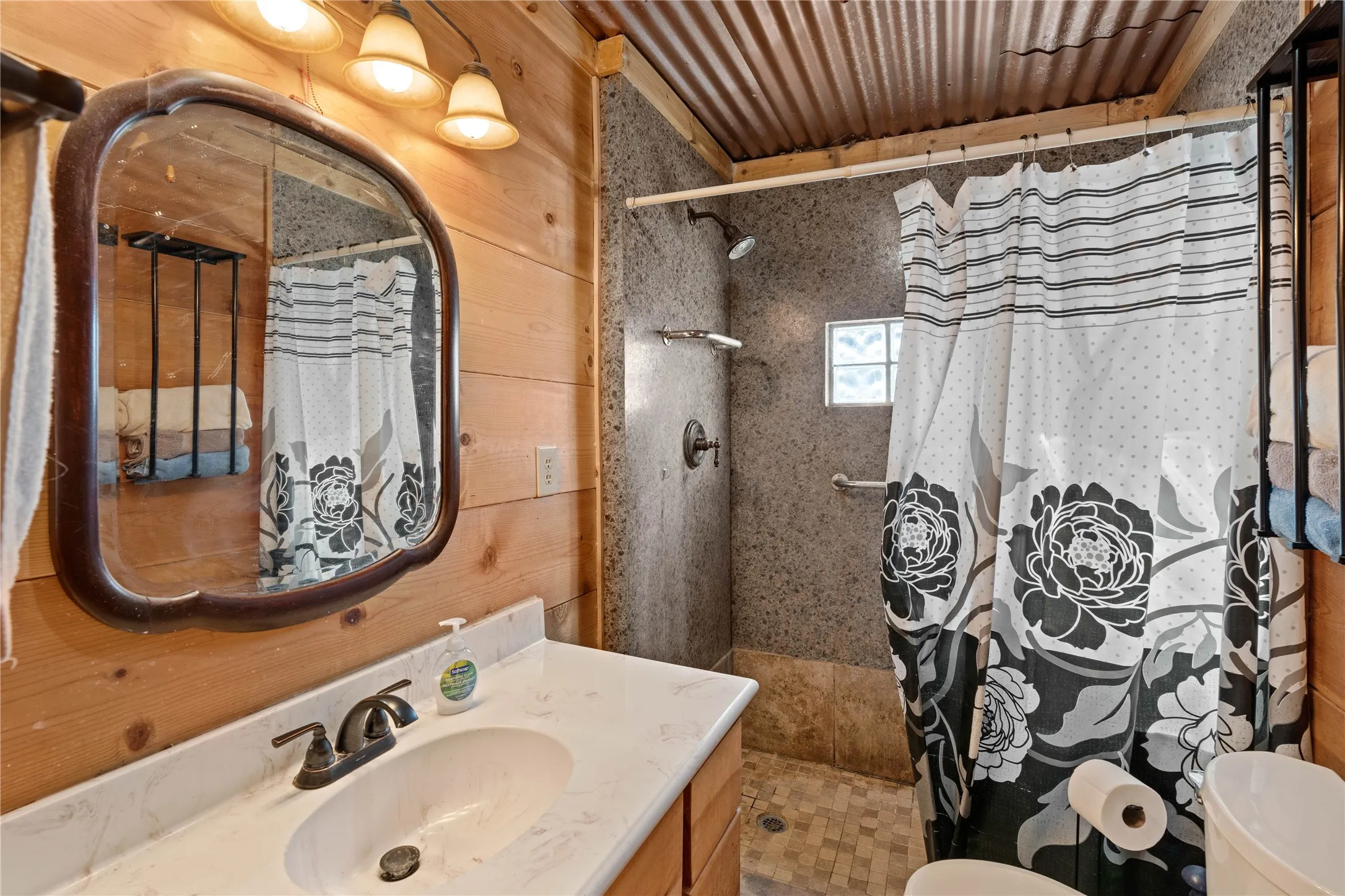 Wood-paneled walls with a vanity featuring a white countertop and an undermount sink