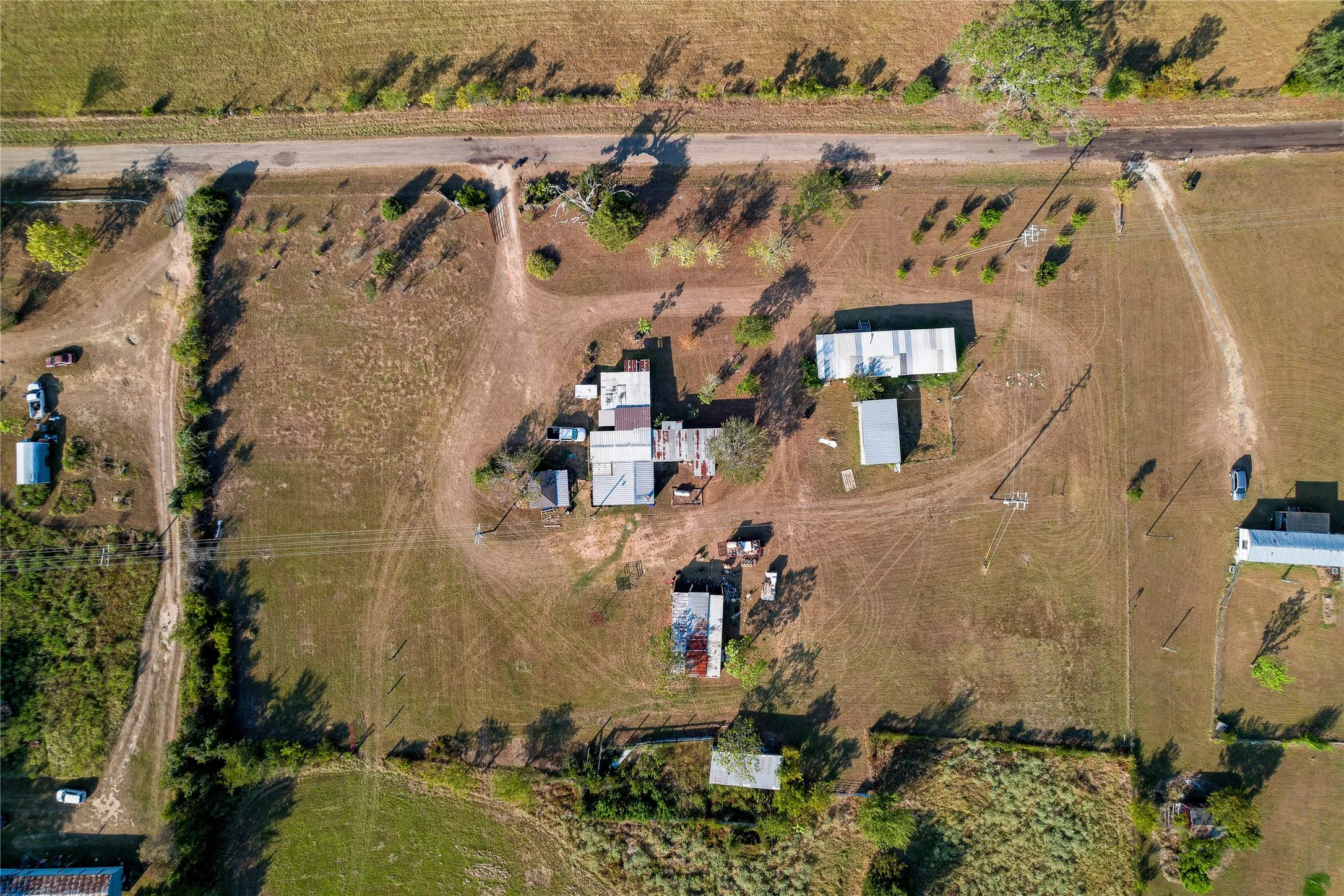 Expansive acreage featuring multiple outbuildings, mature trees, and a private drive