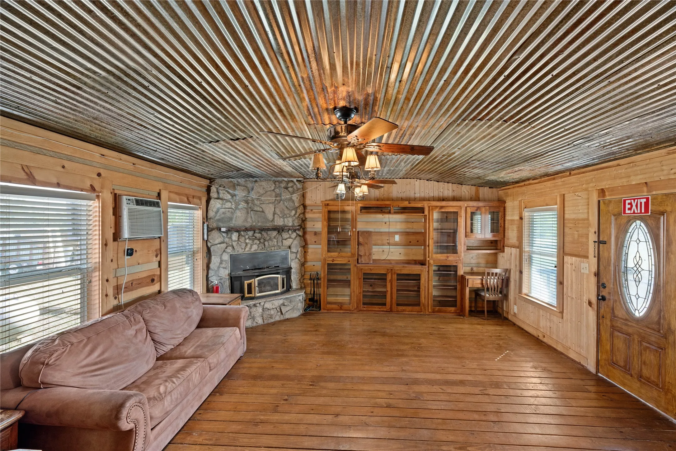 Wood-finish flooring with wood paneling and a corrugated metal ceiling