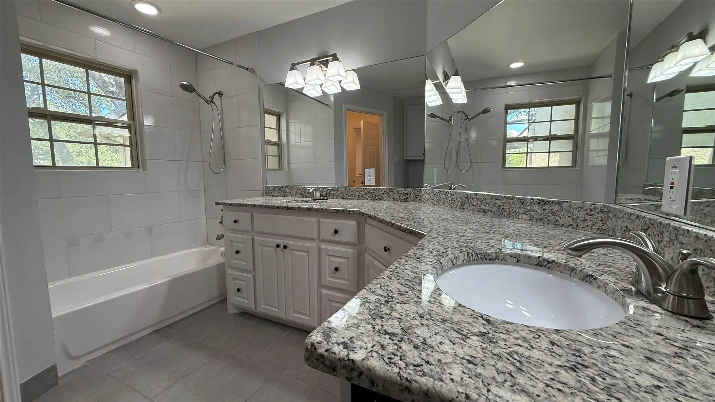 Double vanity with stone-finish countertops, undermount sinks, and brushed nickel fixtures