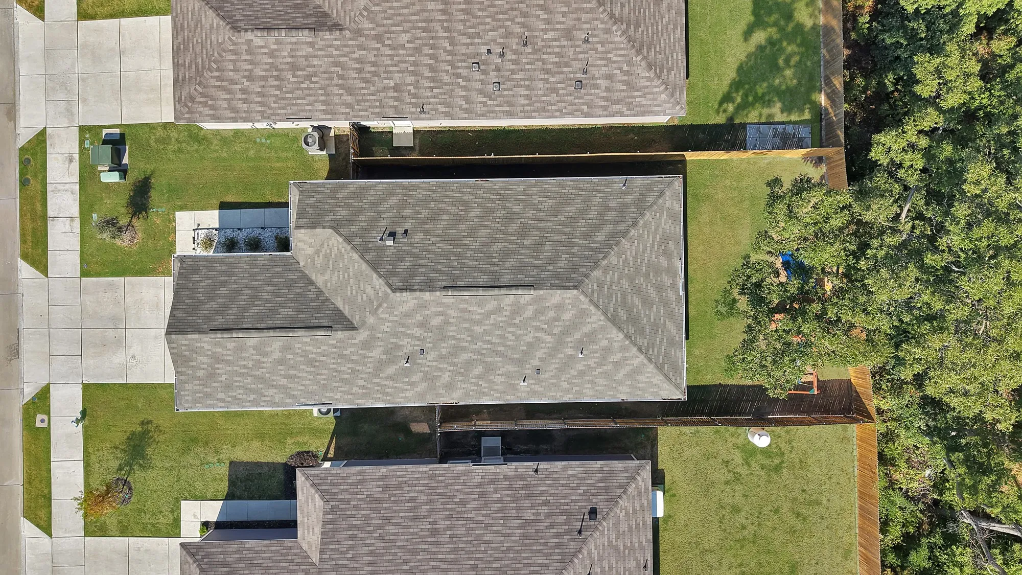 Manicured front and rear lawns, fenced backyard, and mature trees