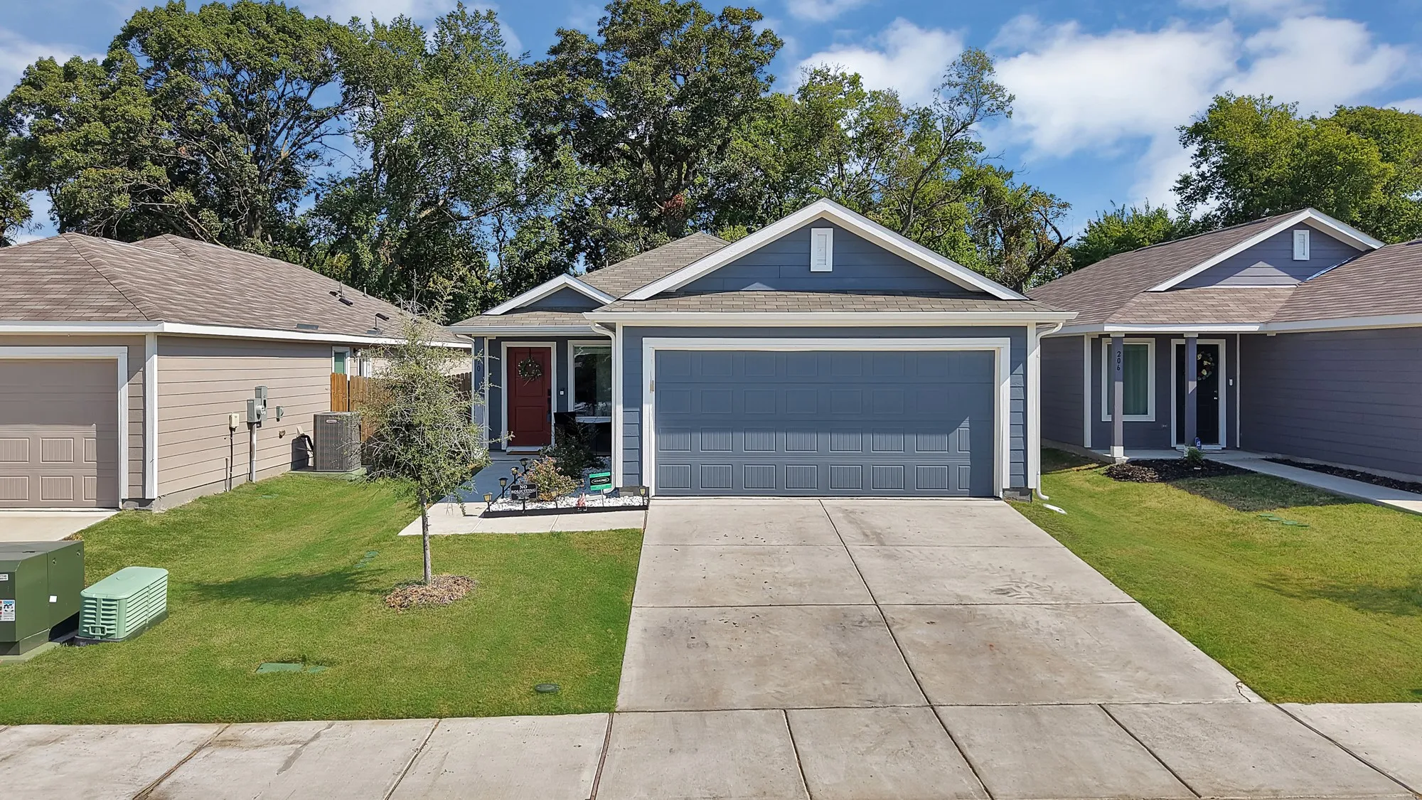 Single-story residence featuring a blue siding exterior, attached garage, and a concrete driveway