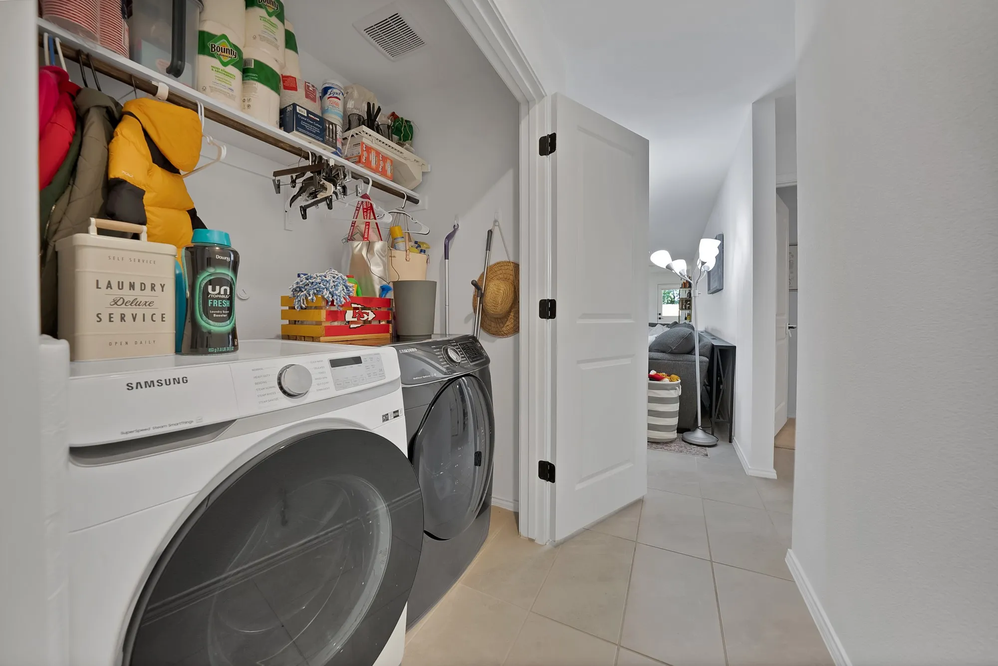 Dedicated laundry space featuring a built-in shelf and hanging rod