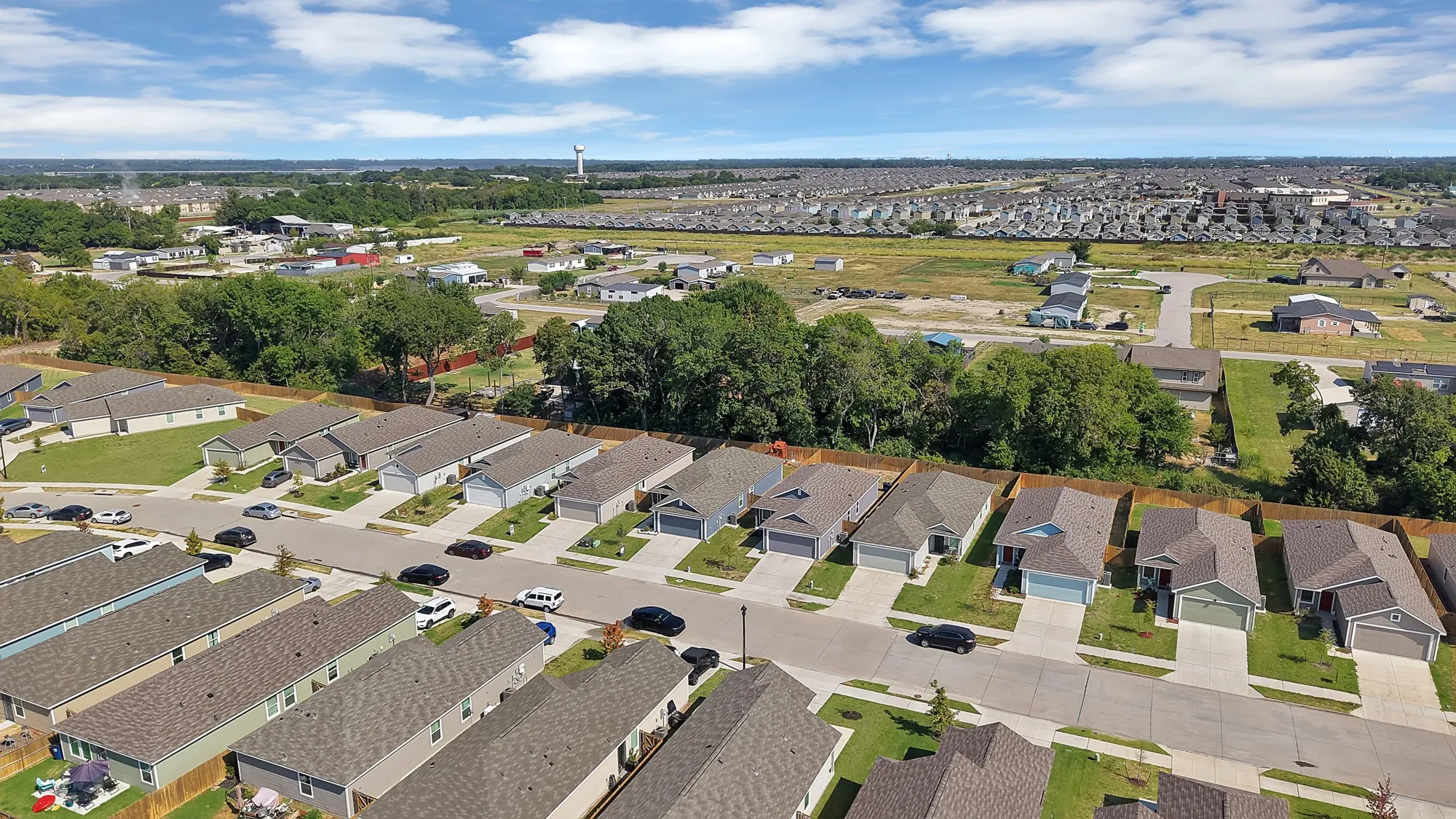 Residential street with multiple single-story homes featuring attached garages and landscaped front yards