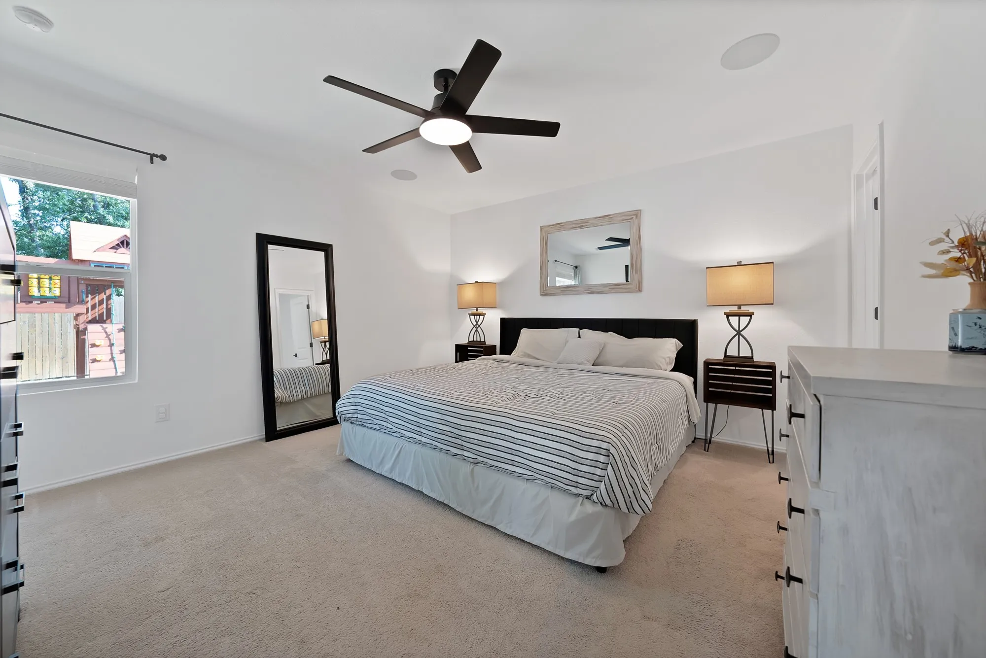 Recessed ceiling speakers, a ceiling fan with integrated lighting, and carpeted flooring