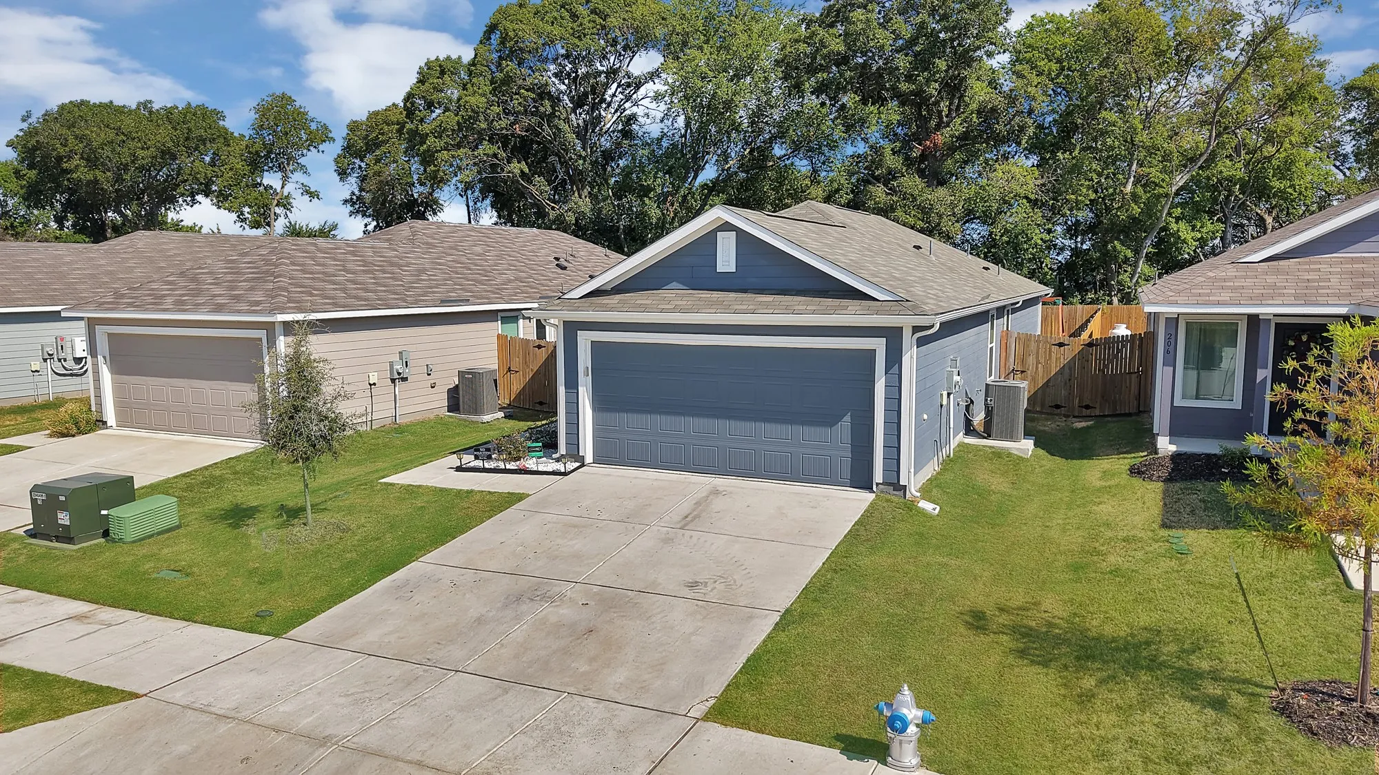 Single-story residence featuring a two-car garage, concrete driveway, and a fenced side yard