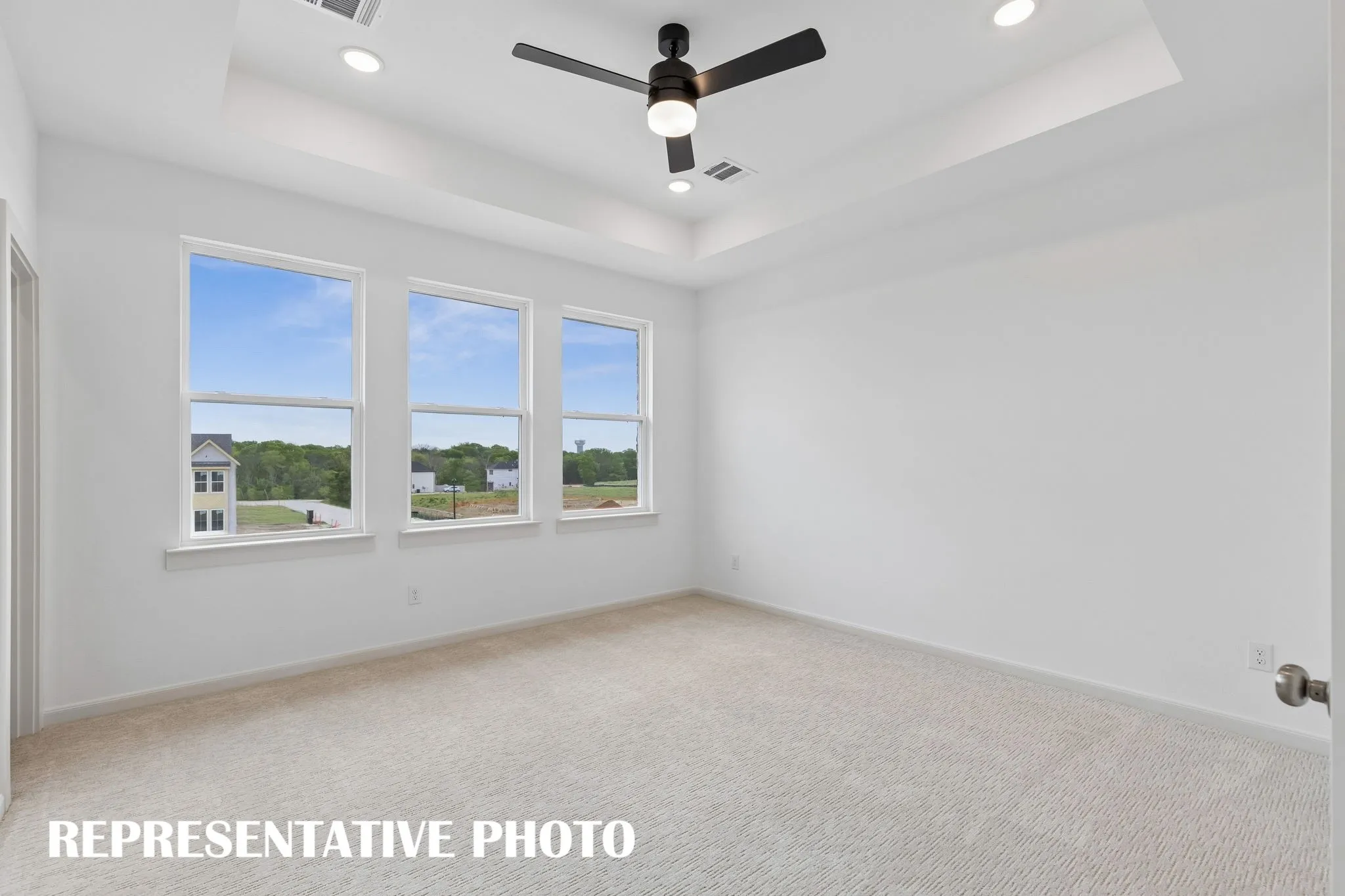 Featuring high ceilings, a wall of windows and plush carpeting, this dreamy new owner' suite is the perfect place to relax at the end of the day.  REPRESENTATIVE PHOTO