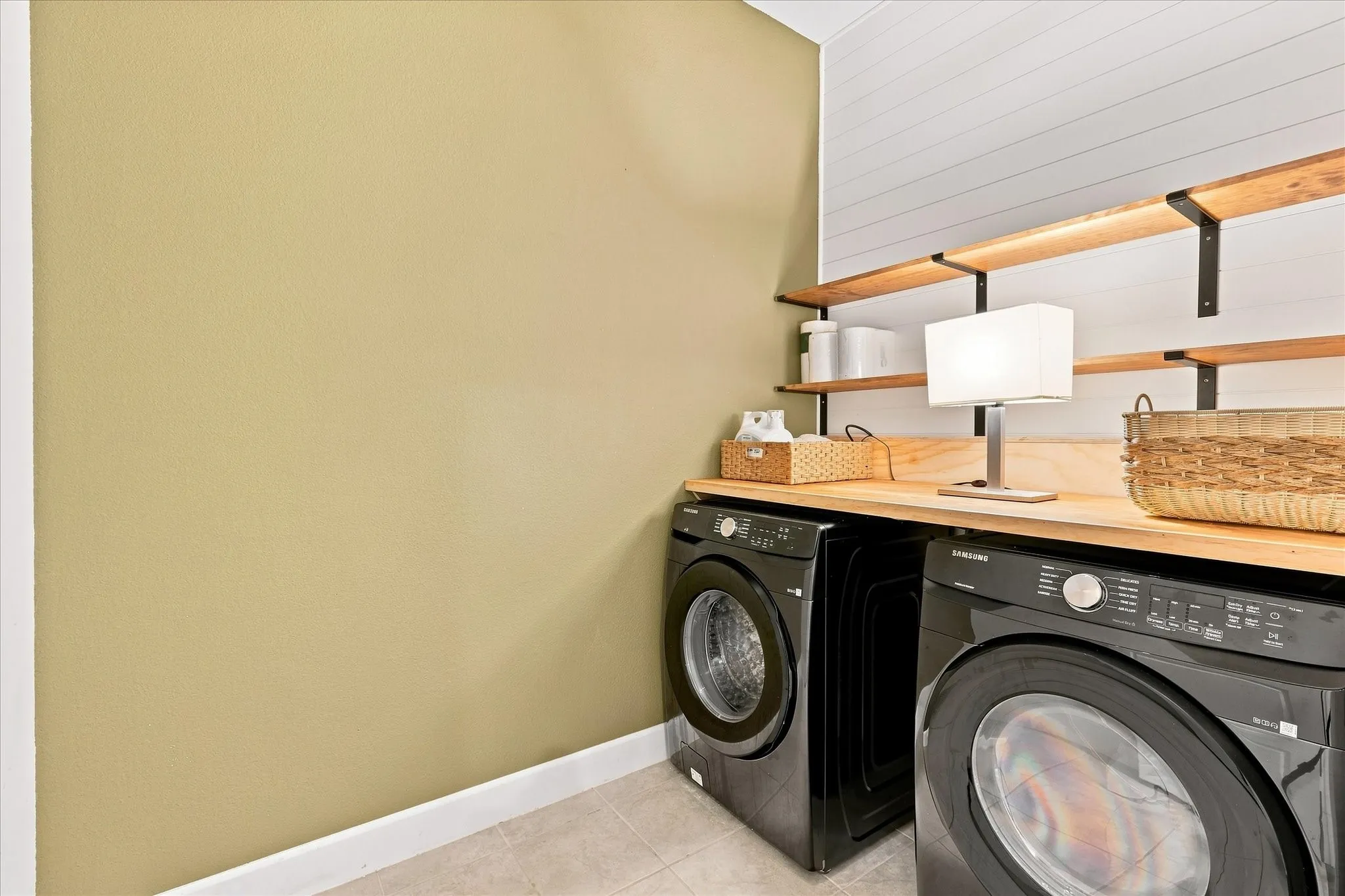 Spa like laundry room with counter top and shelves!