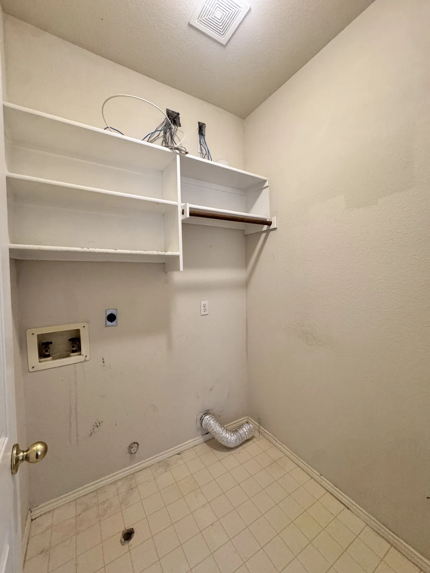 Built-in shelving with hanging rod, tile flooring, and ceiling-mounted exhaust fan