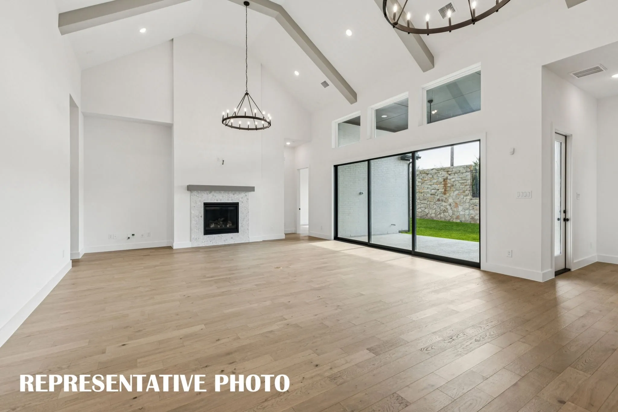 You'll find a grand family room featuring a full wall slider and charming fireplace in this dream home!  REPRESENTATIVE PHOTO
