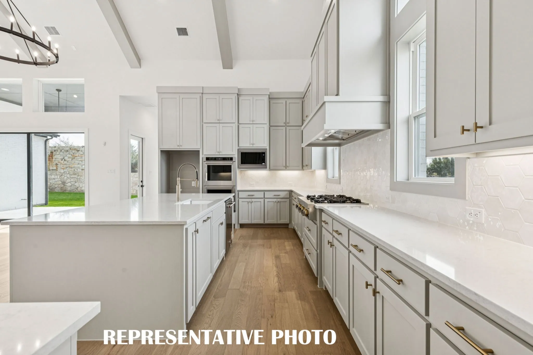 Gorgeous cabinetry, beautiful countertops, and stylish backsplash paired with top of the line stainless steel appliances effortlessly blend together to create the kitchen of your dreams!  REPRESENTATIVE PHOTO