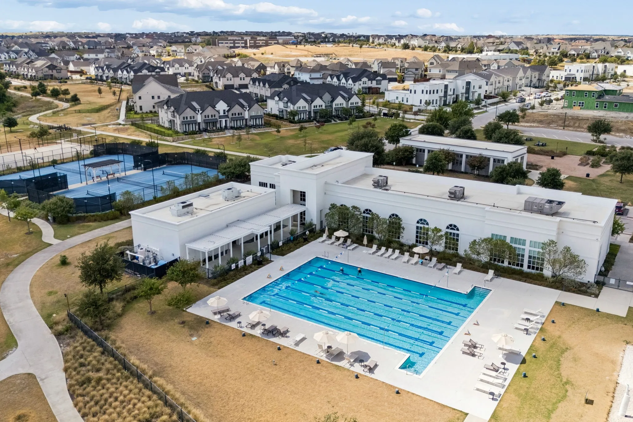 View of another community pool, tennis courts, and back of fitness center.